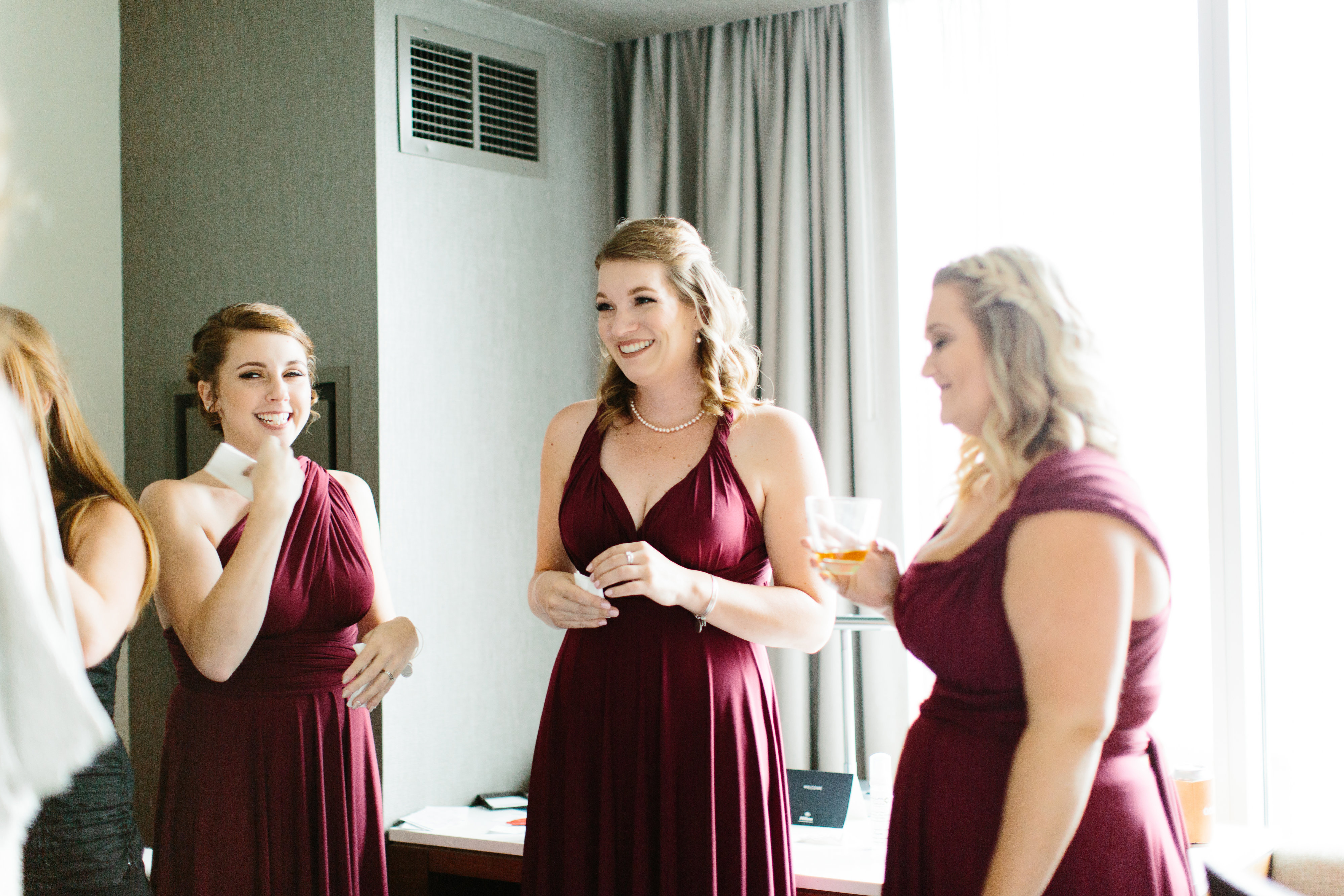 smiling bridesmaids in maroon dresses