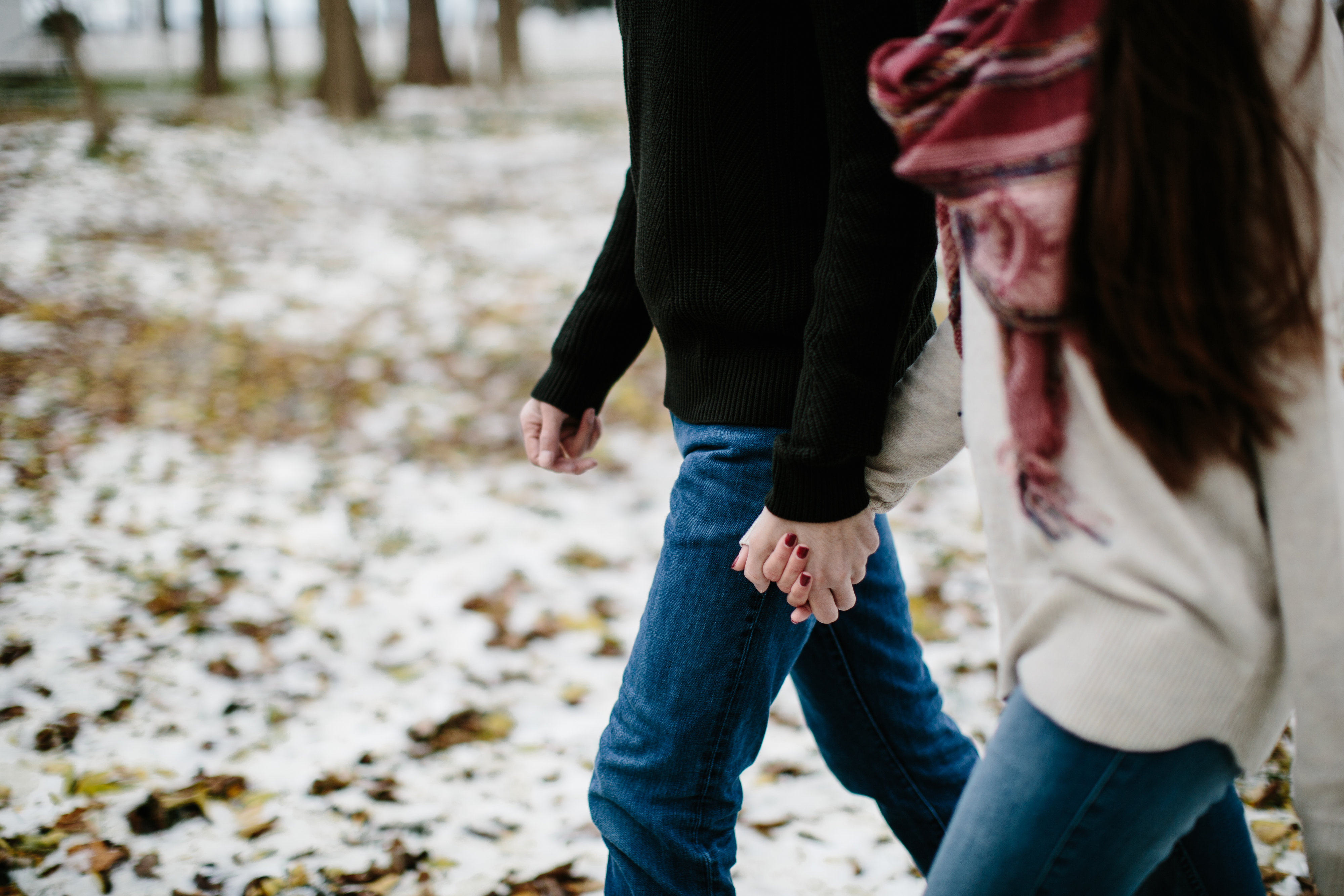 couple hold hands while walking