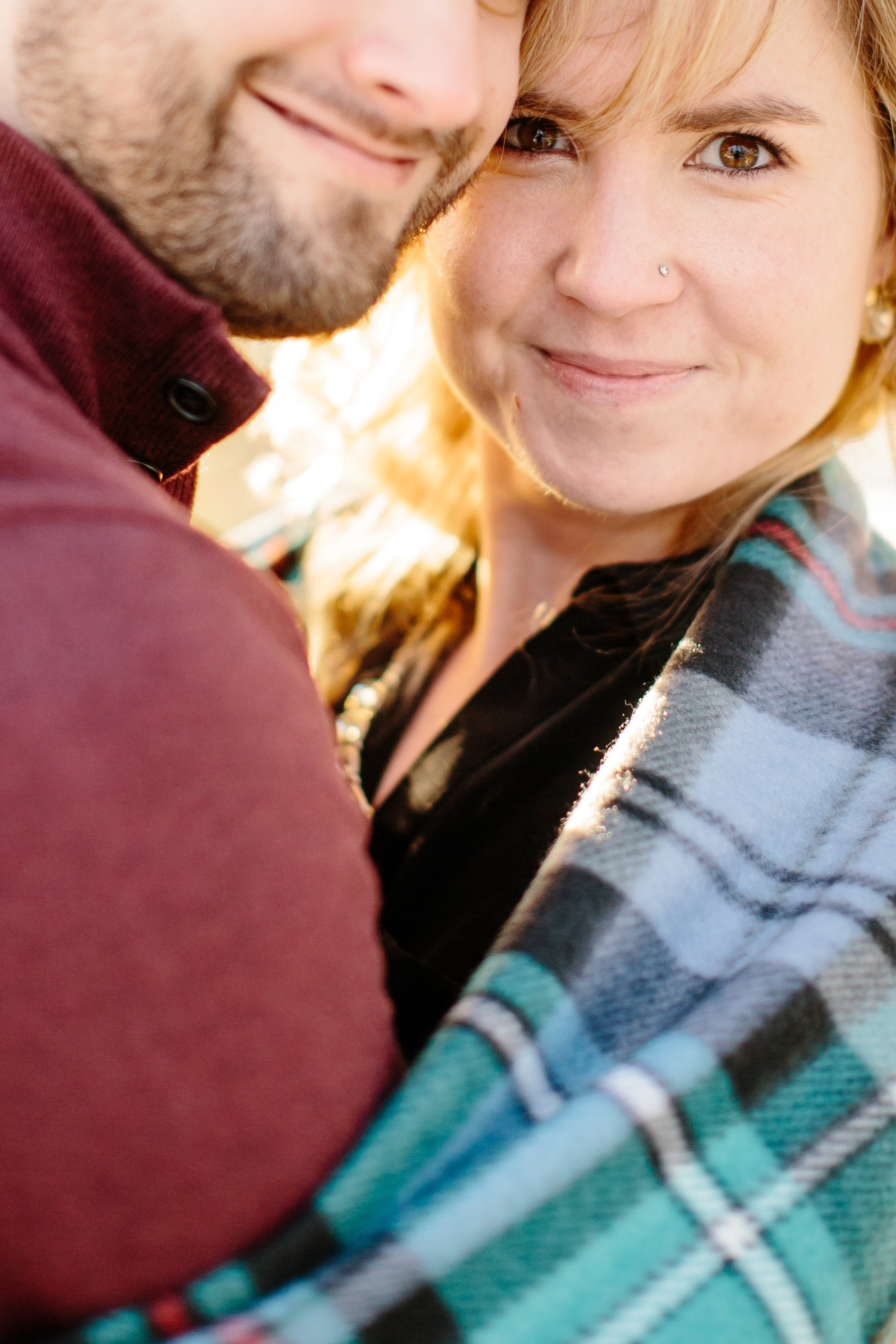 Couple wrapped up in blanket during engagement session