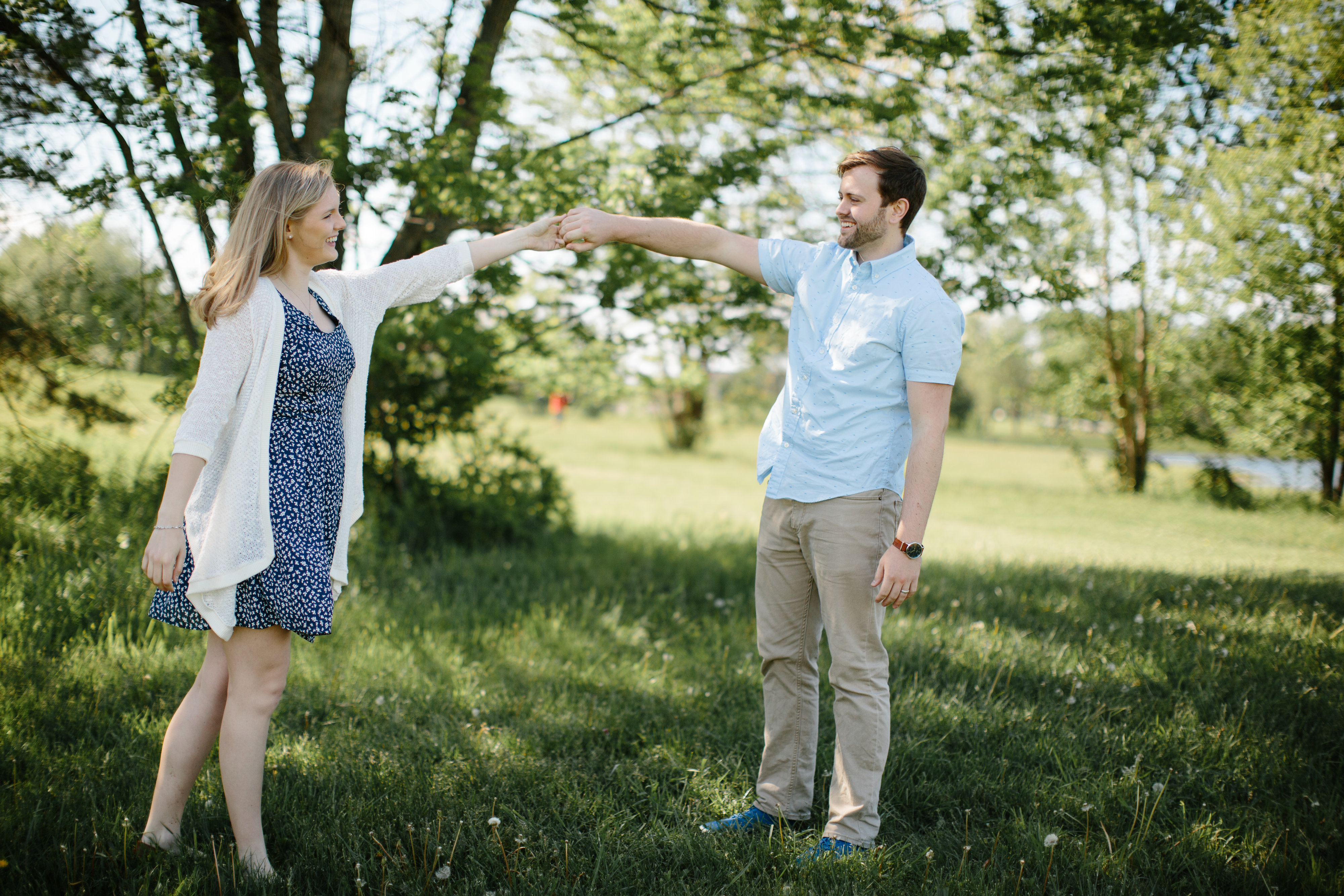 Couple dancing in field during engagement session