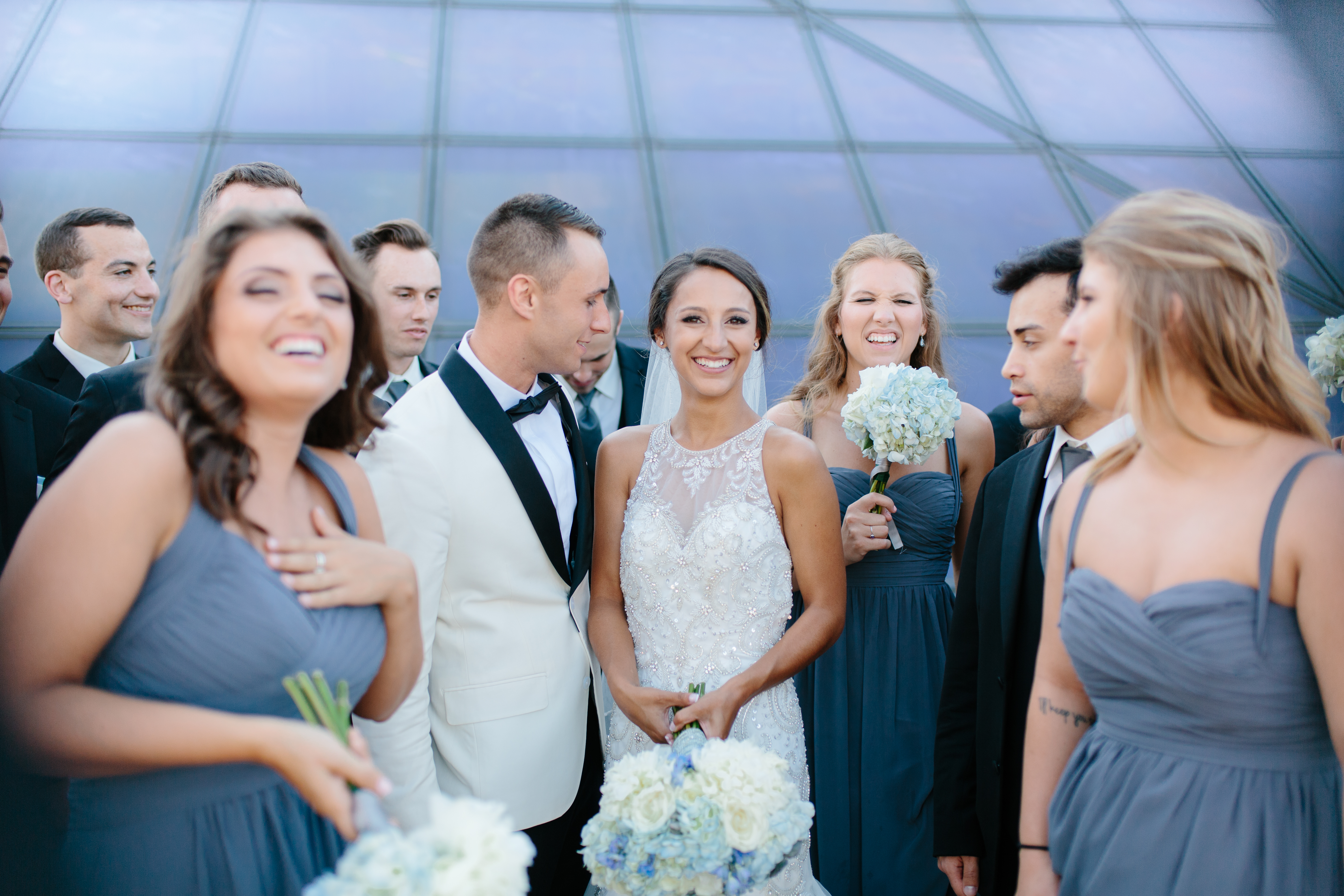 Bridal party laughing in front of Cleveland Rock Hall