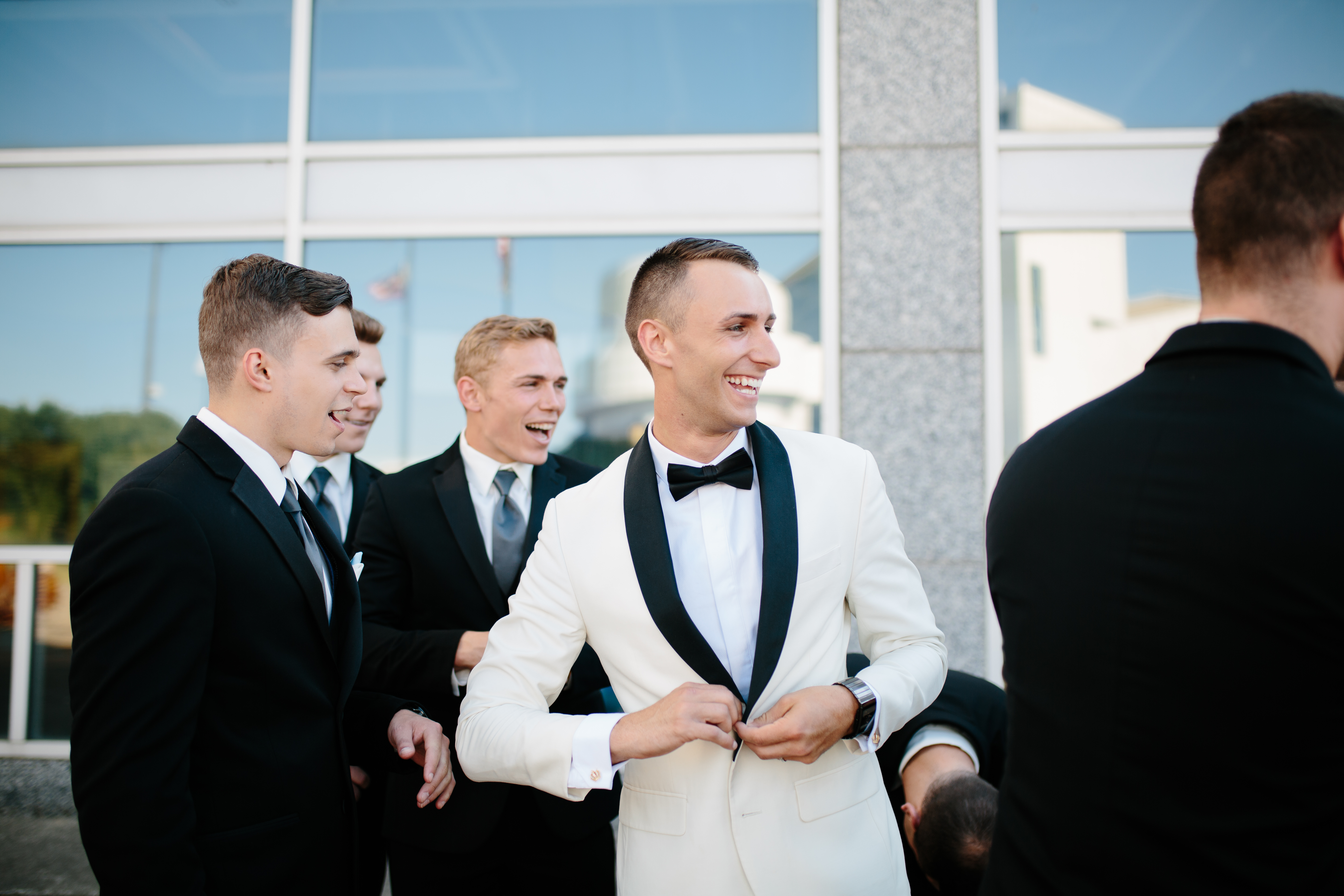 Groom laughs with groomsmen