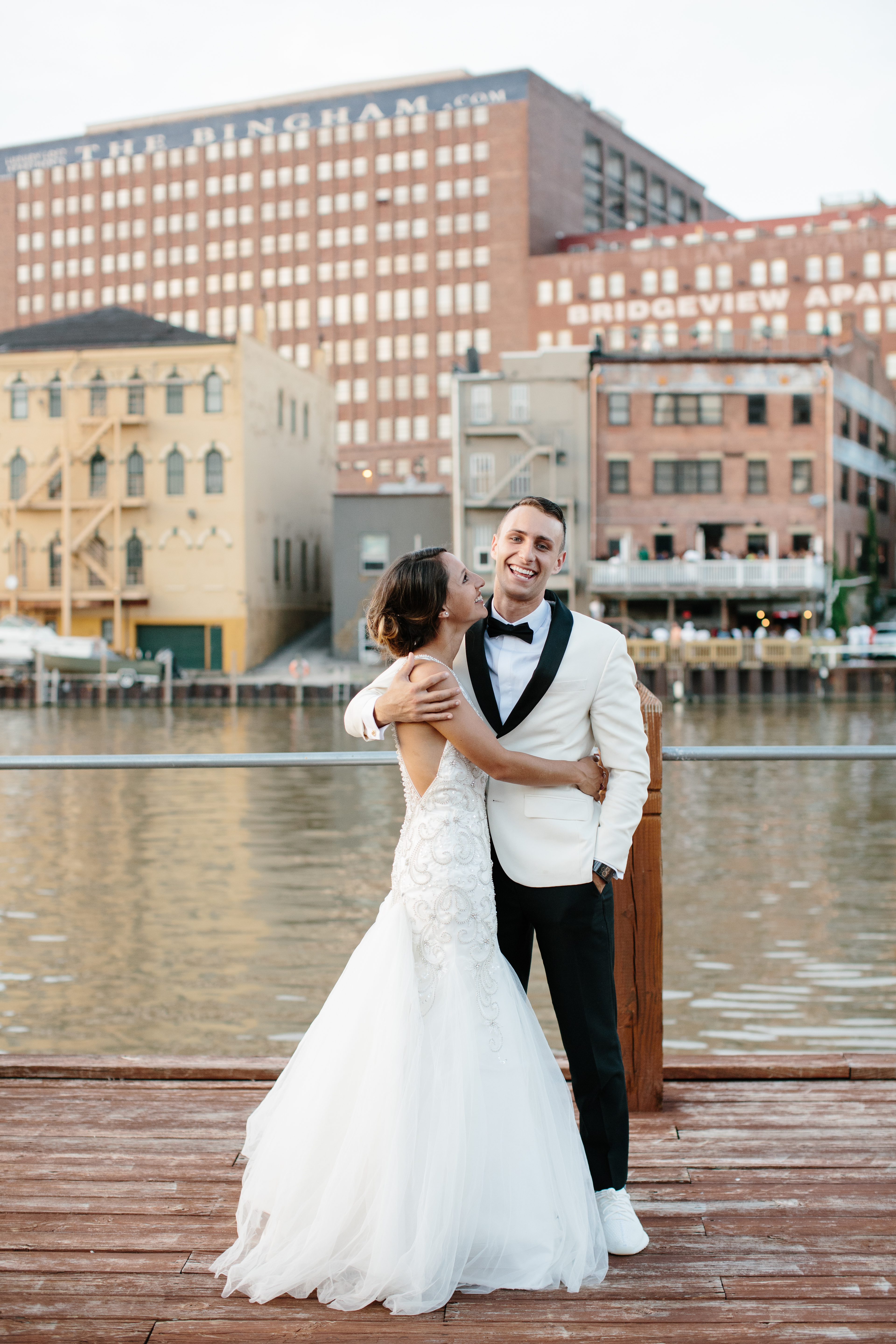 Couple laugh by lake erie during wedding