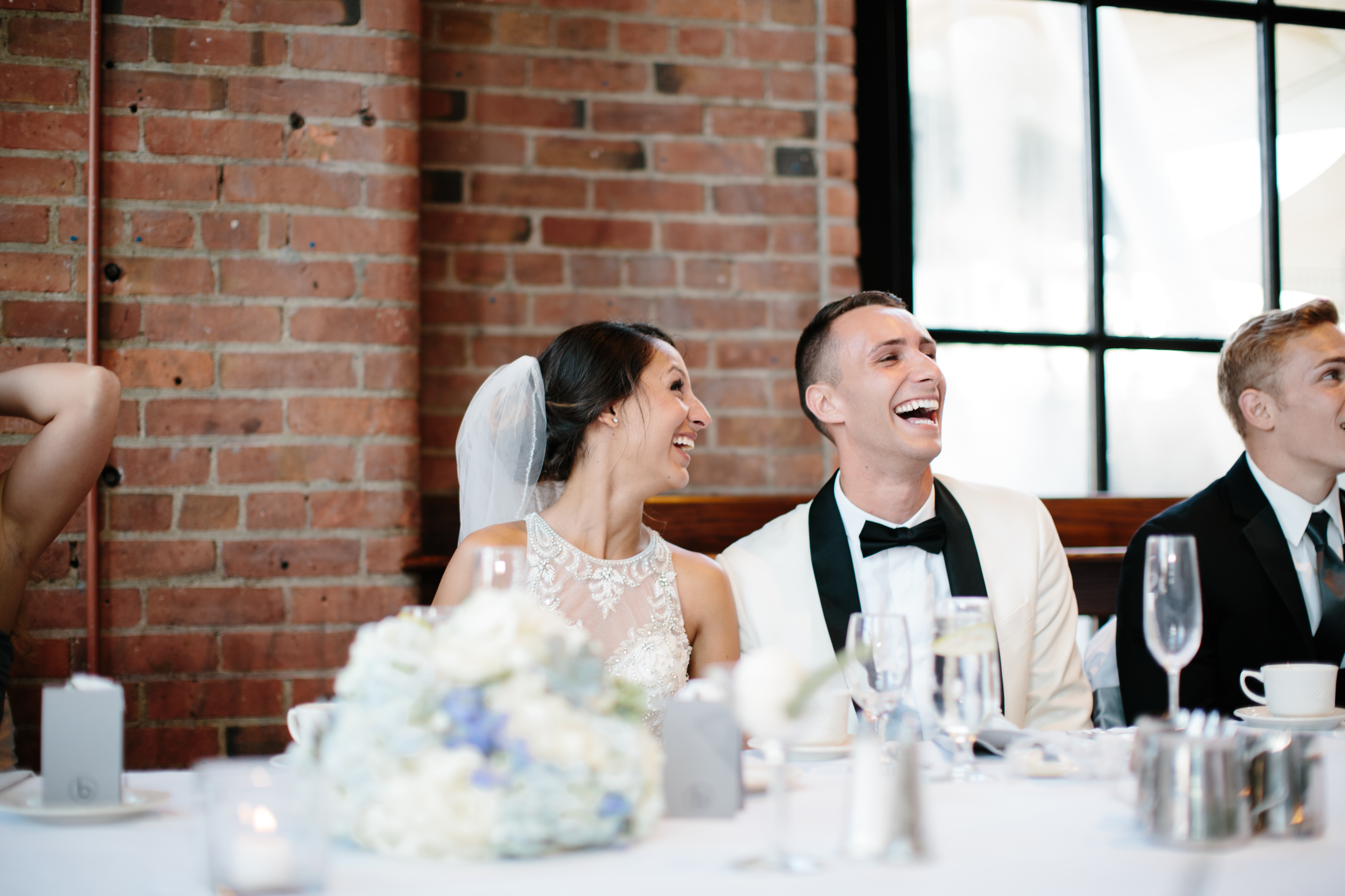 Bride and groom laugh during industrial reception