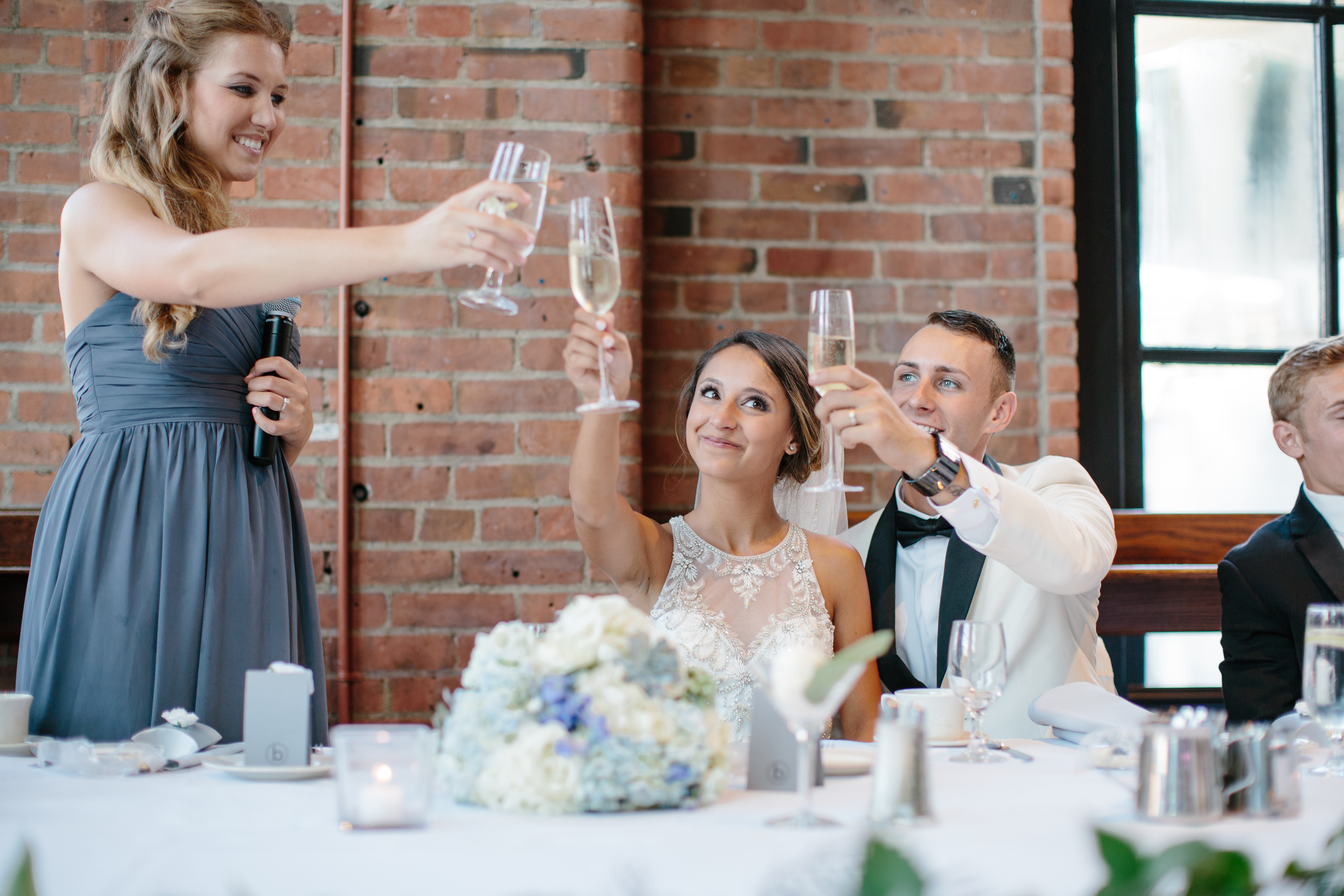 Bride and groom raise glasses to toast