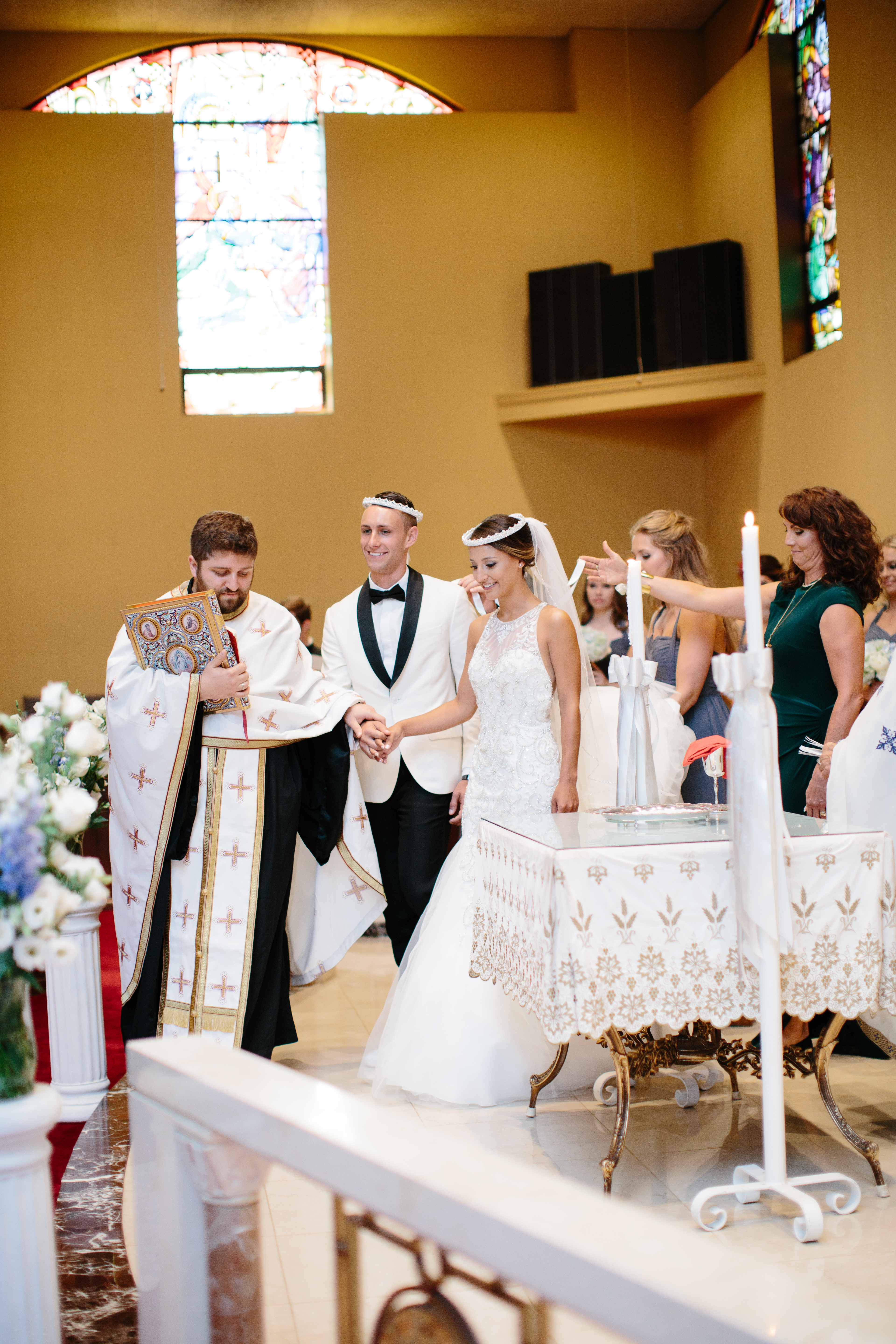 Couple walks around altar during traditional greek wedding