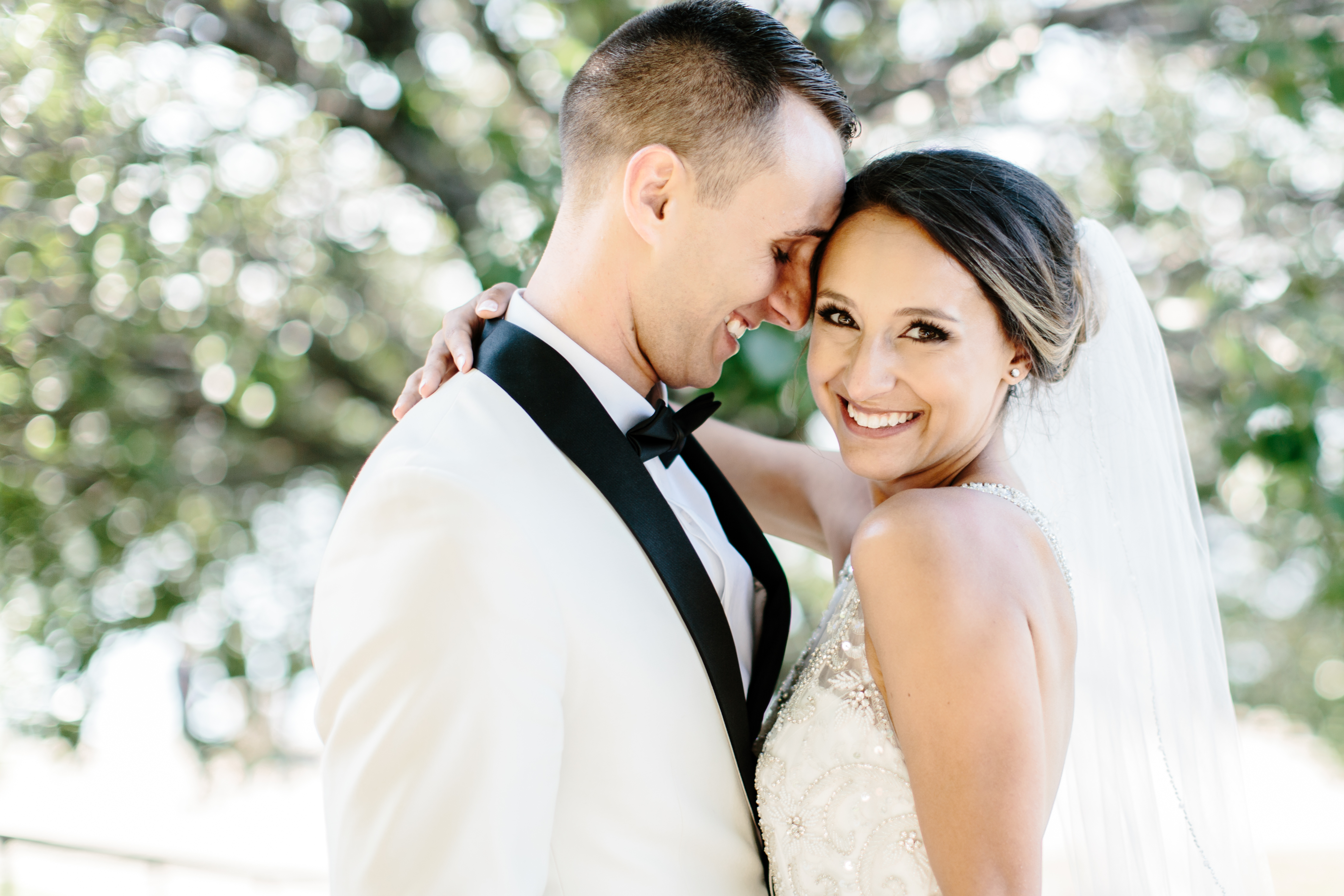 Groom whispers in brides ear during pictures