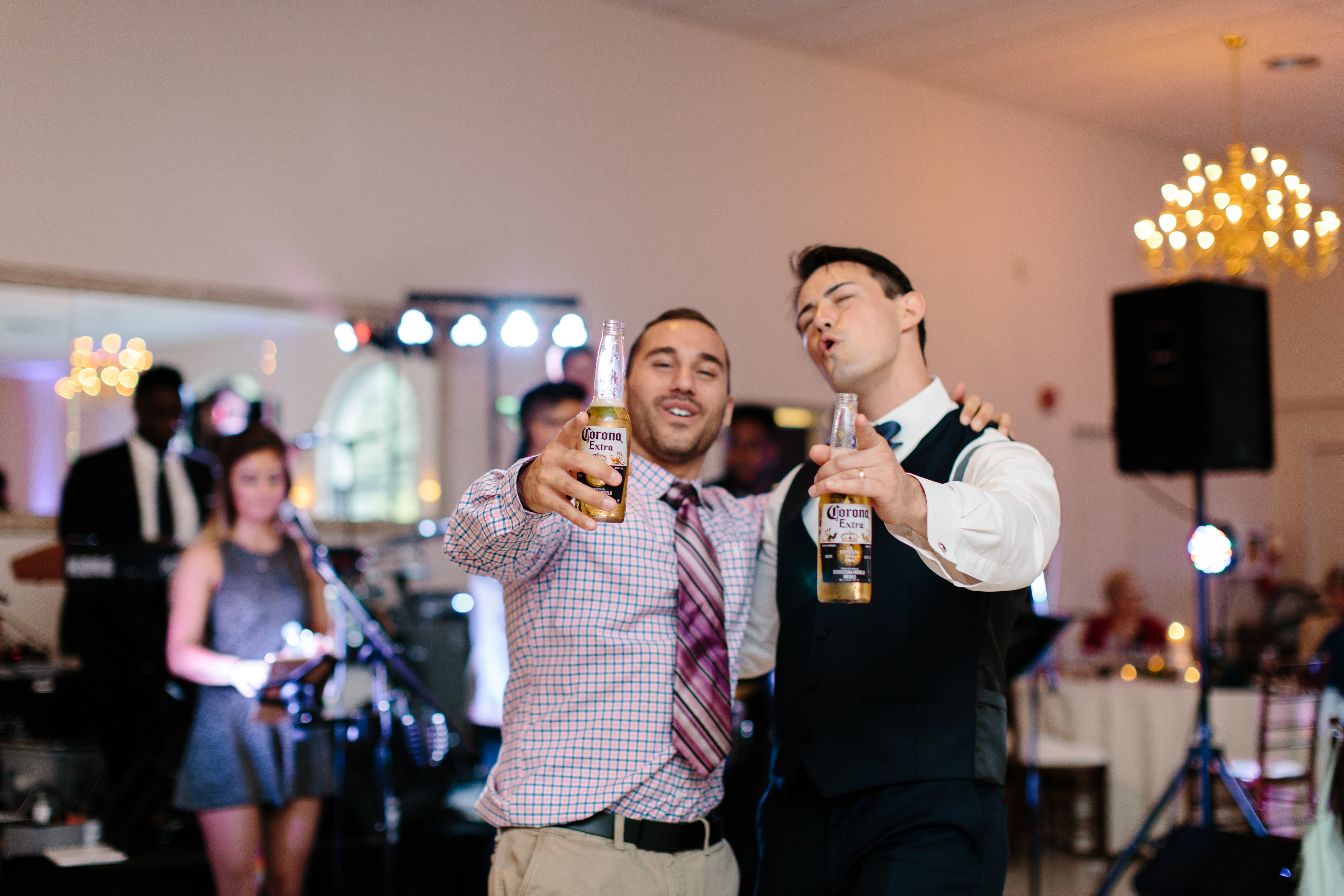 groom and friend singing at wedding reception