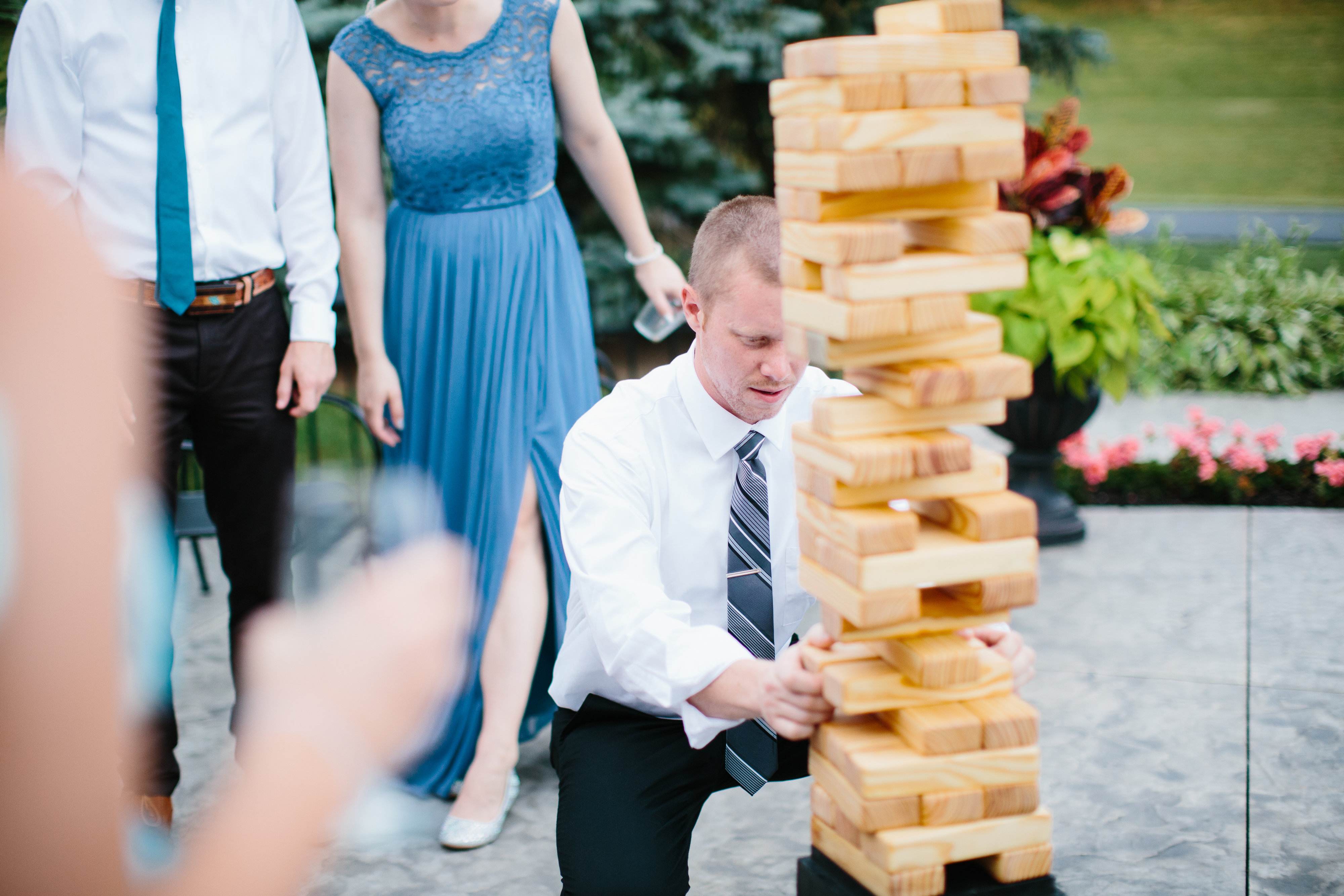 friends play oversized jenga at wedding reception