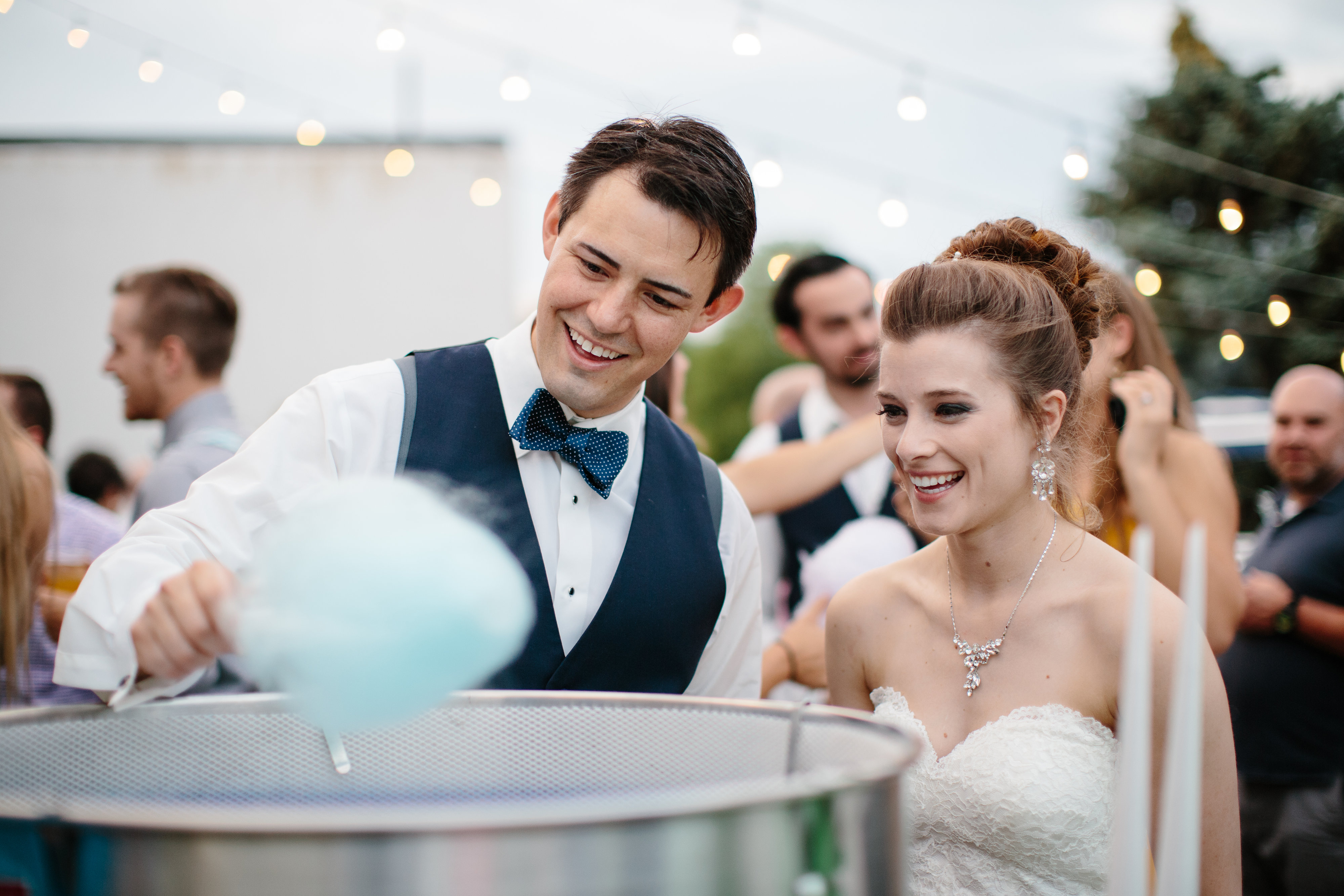 couple make cotton candy at their wedding reception