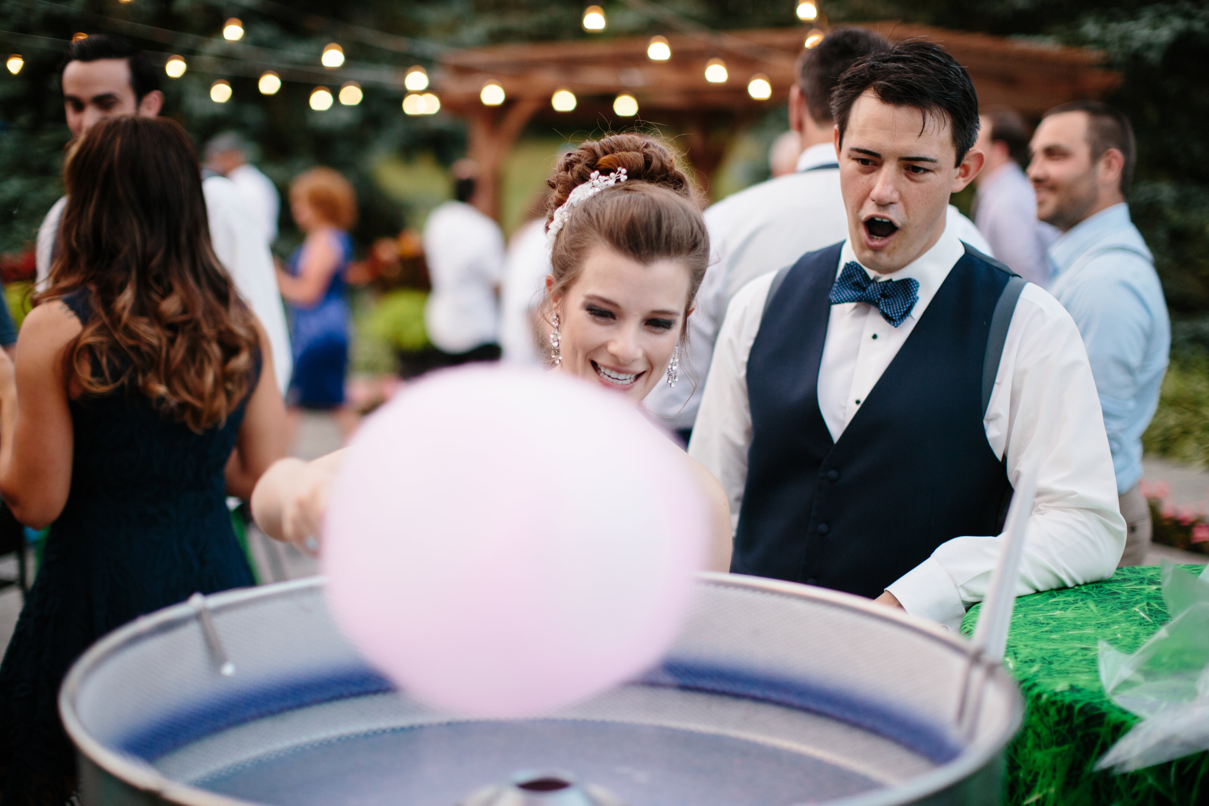 couple make cotton candy at their navy and pink wedding 