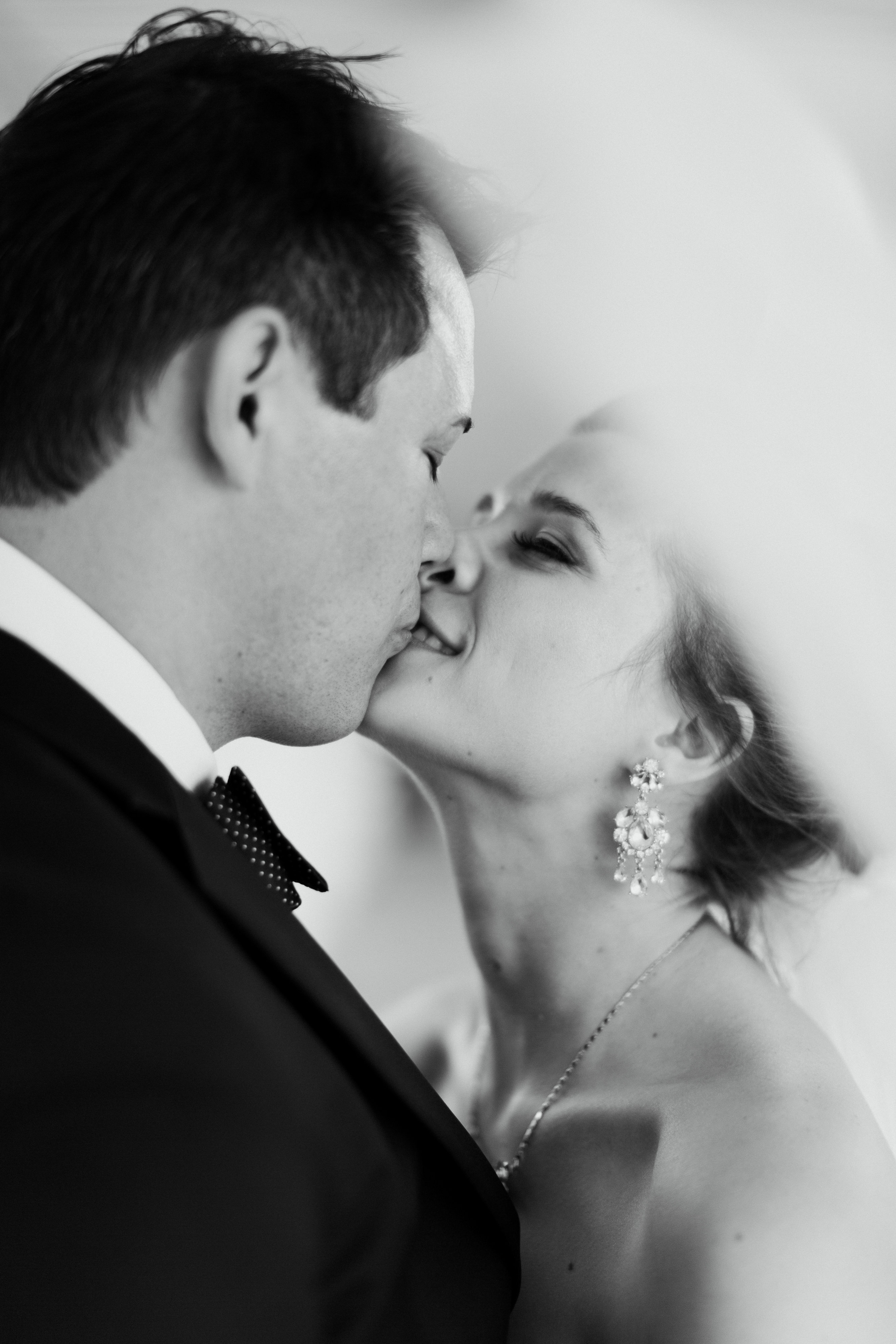 couples kiss under veil at romantic cleveland wedding