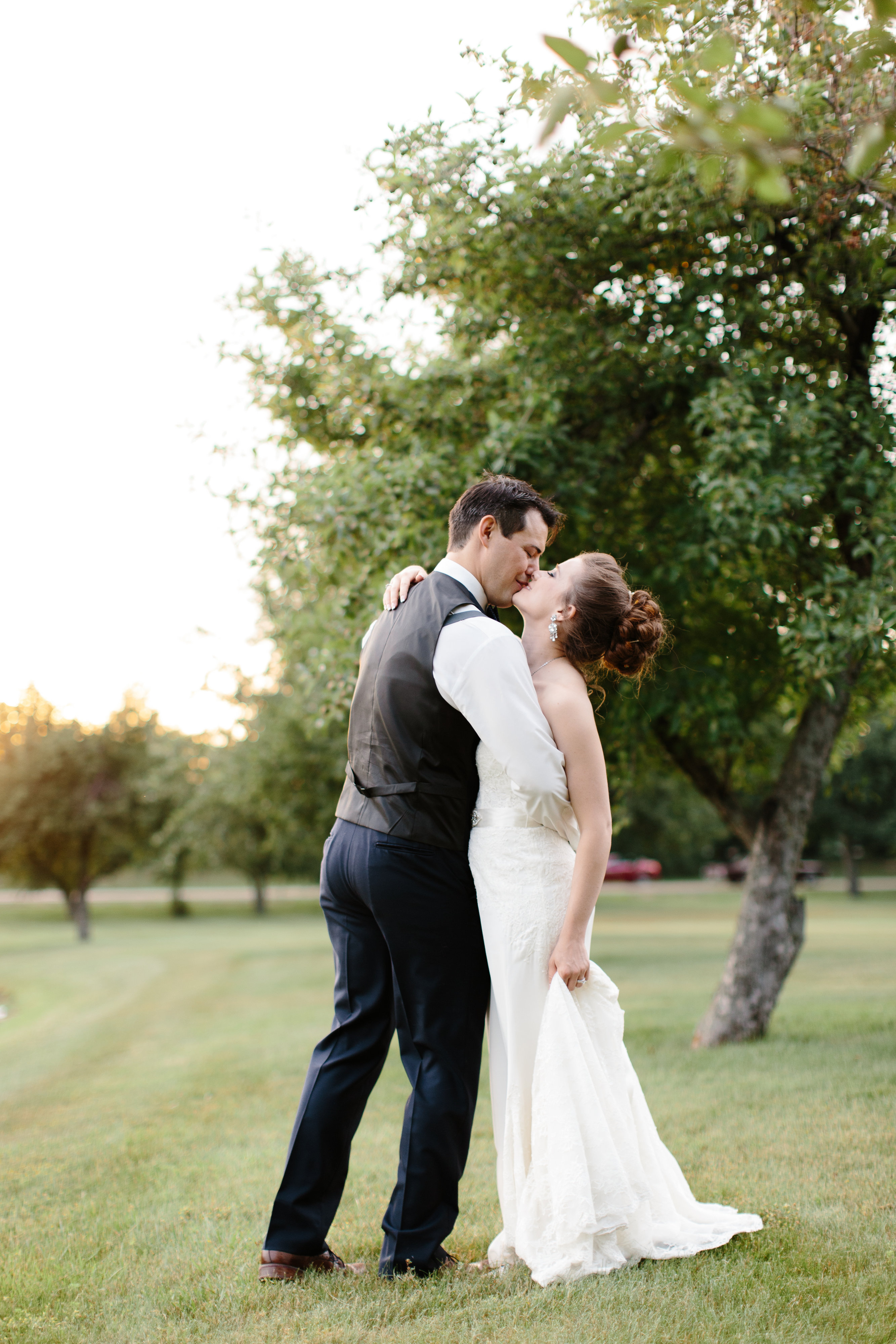 couple kiss during golden hour at their romantic wedding