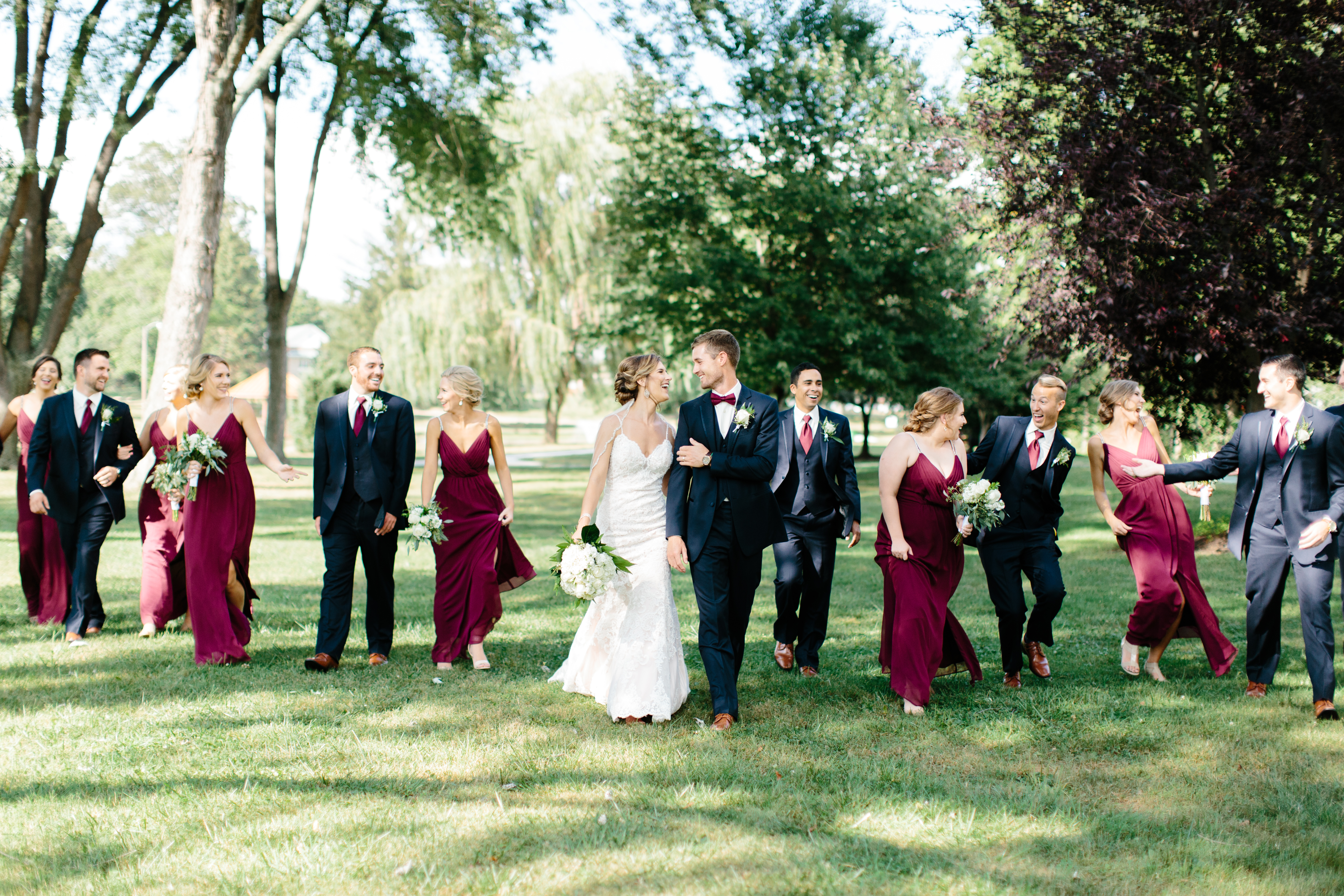 bridal party in maroon and navy walk together