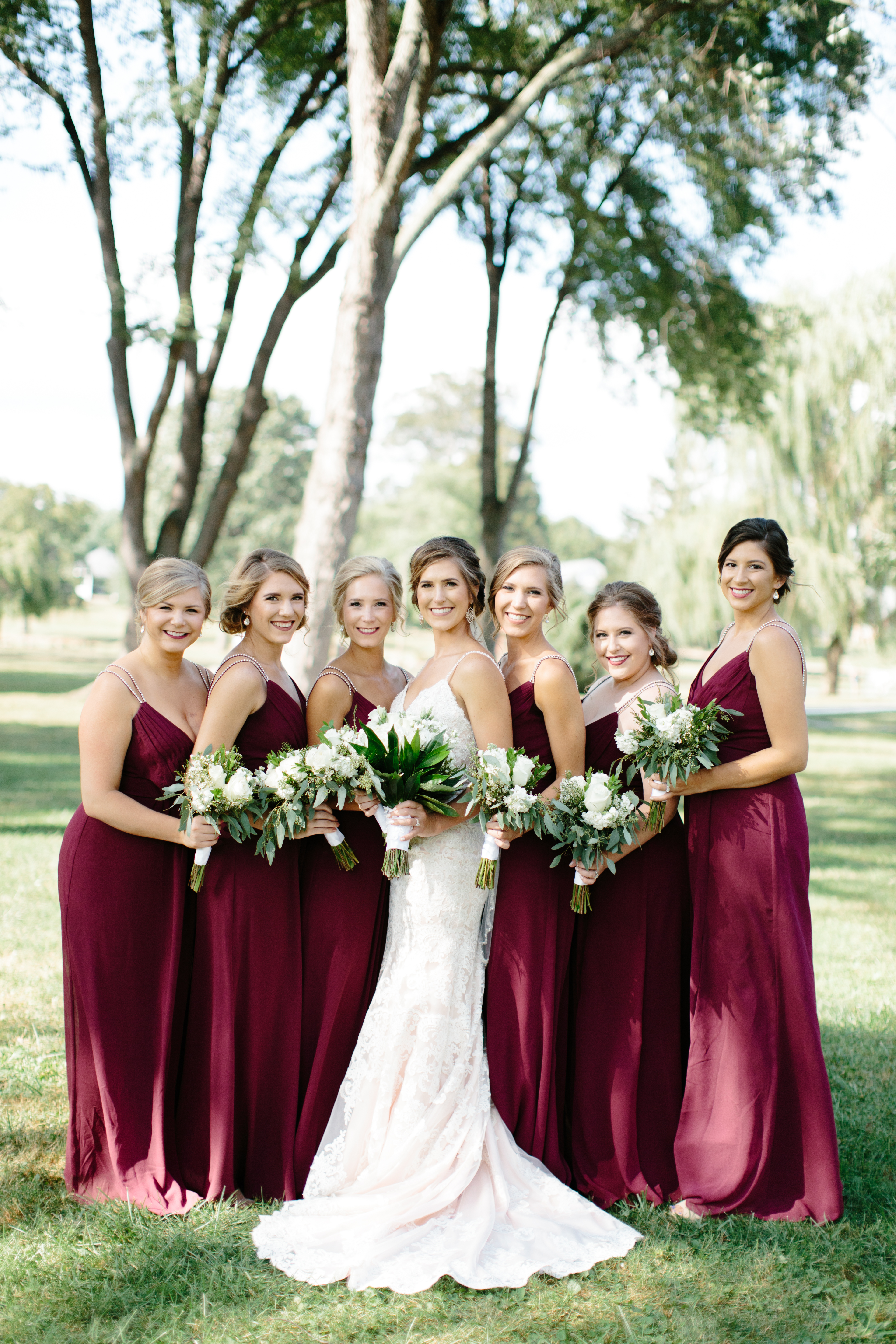 Romantic Maroon bridesmaid dresses with green and white bouquets