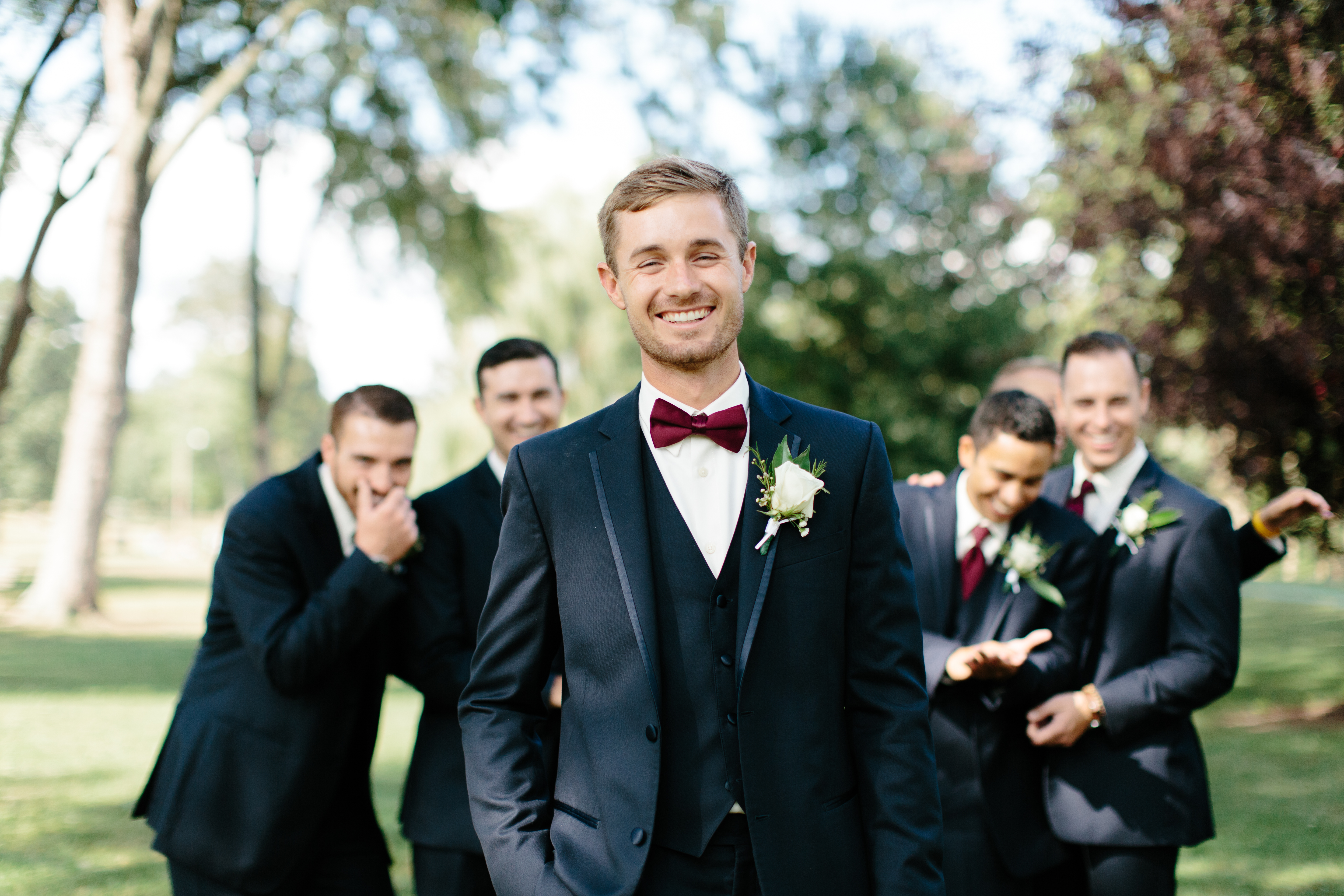 Groom in navy smiles with groomsmen