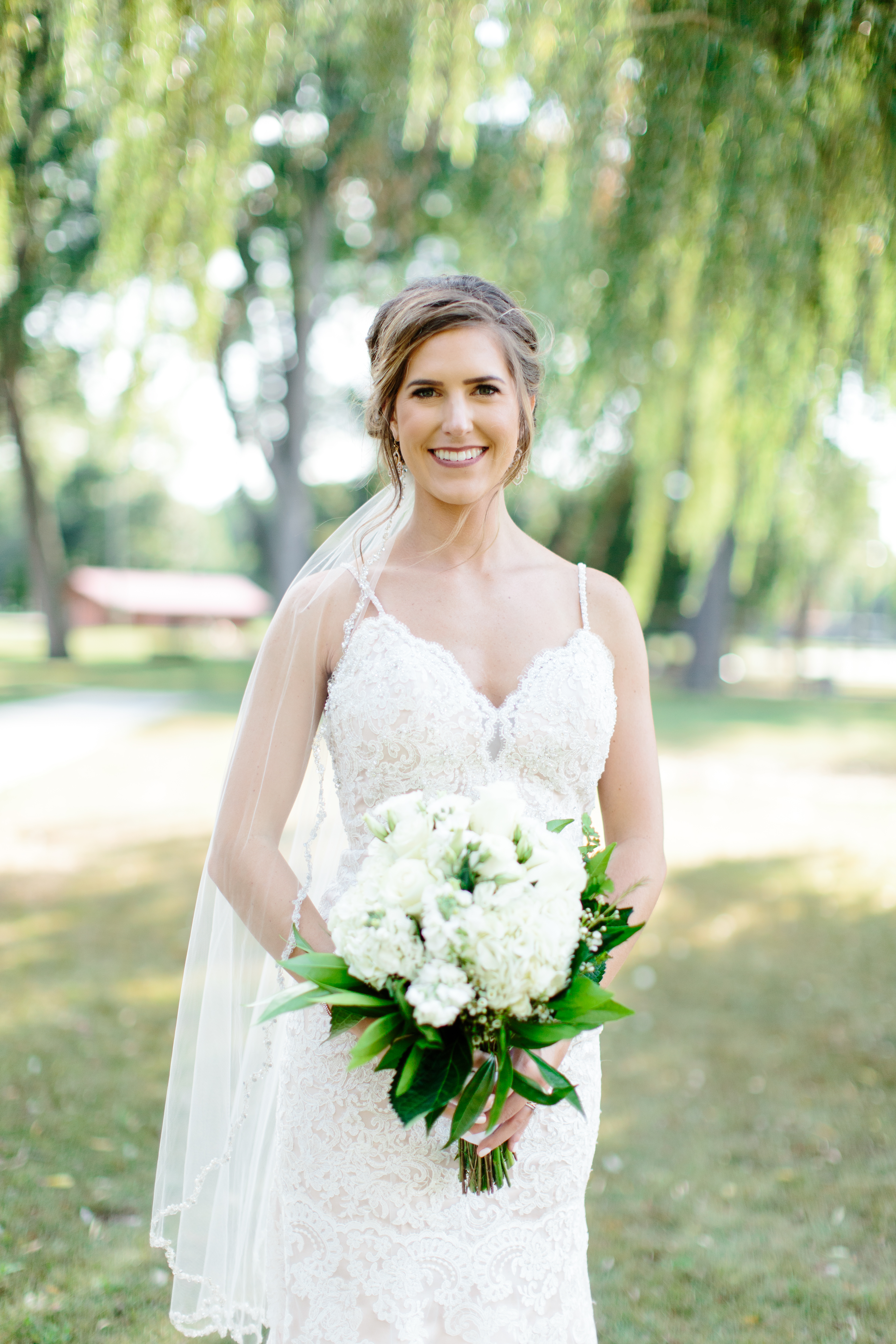 bride in blush wedding dress and green and white bridal bouquet