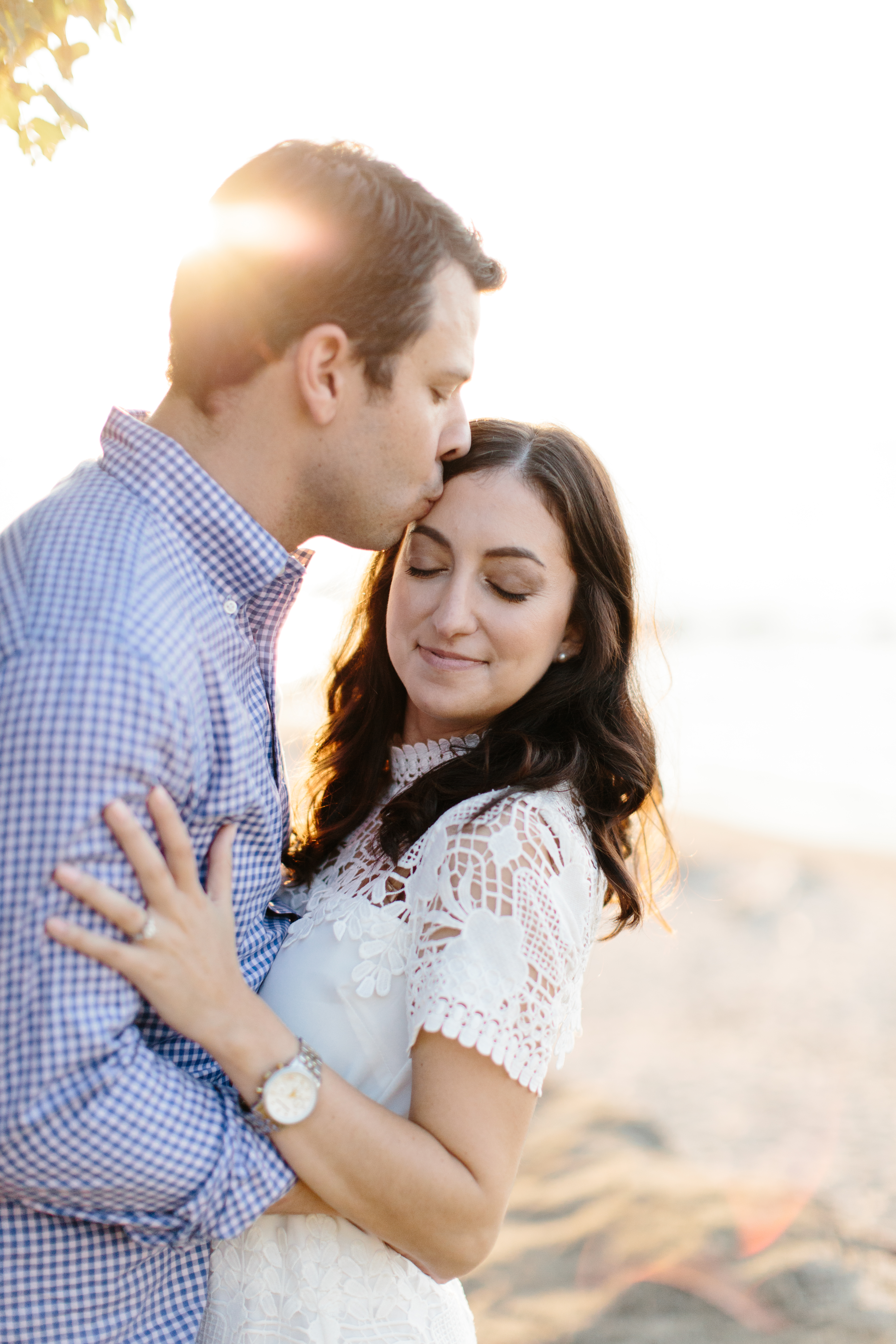 couple snuggling on cleveland beach during engagement session