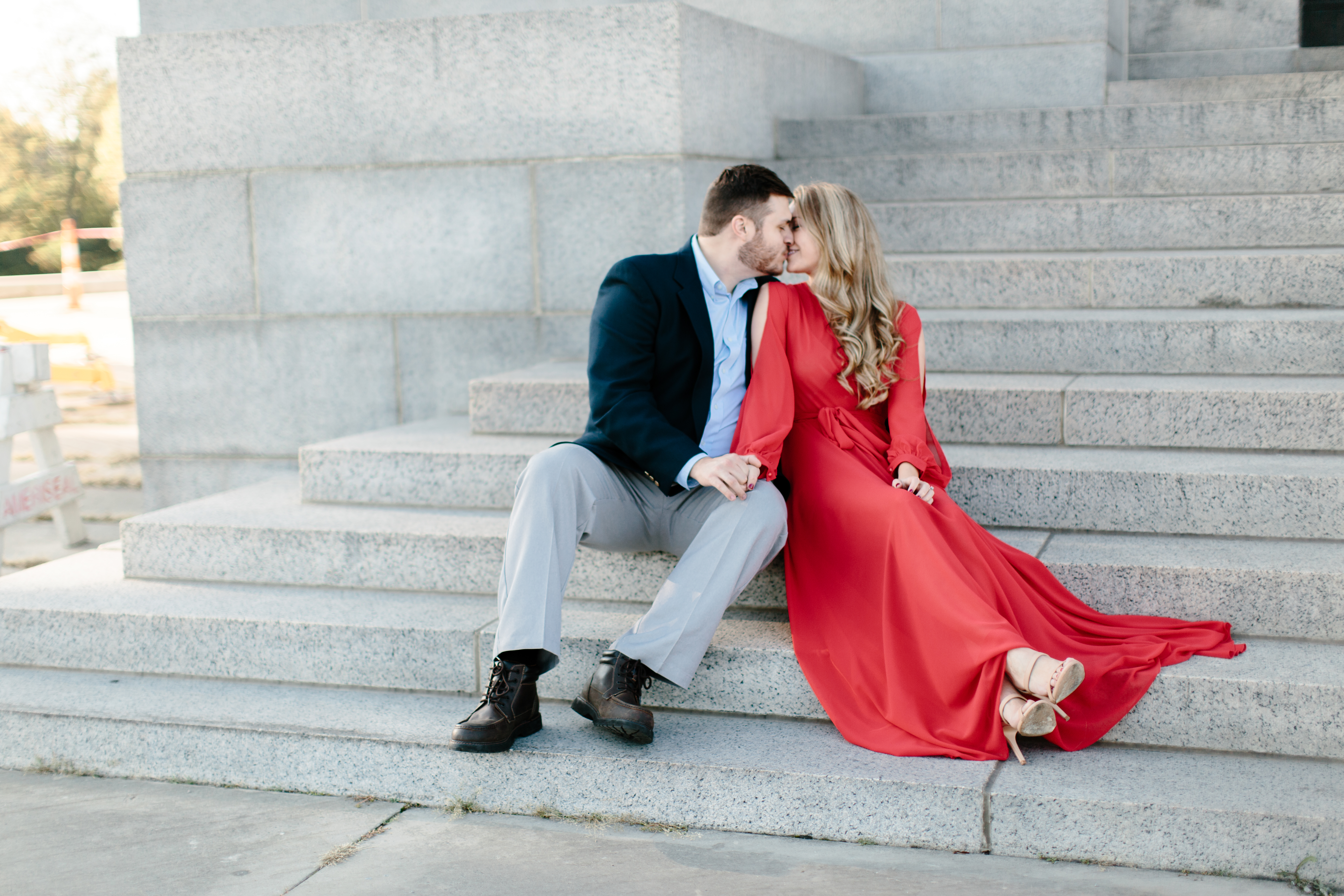 Engaged couple sitting on stairs in romantic red dress