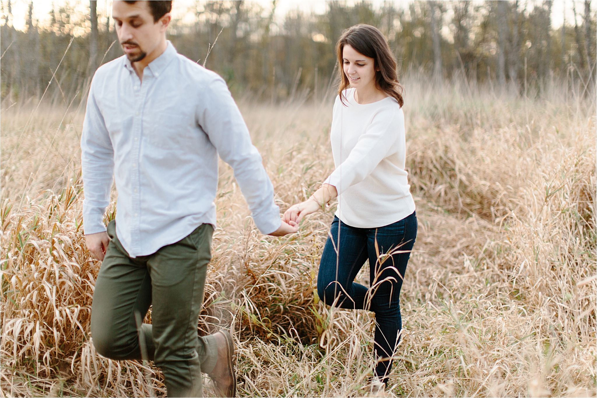 couple holding hands in field ohio engagement session