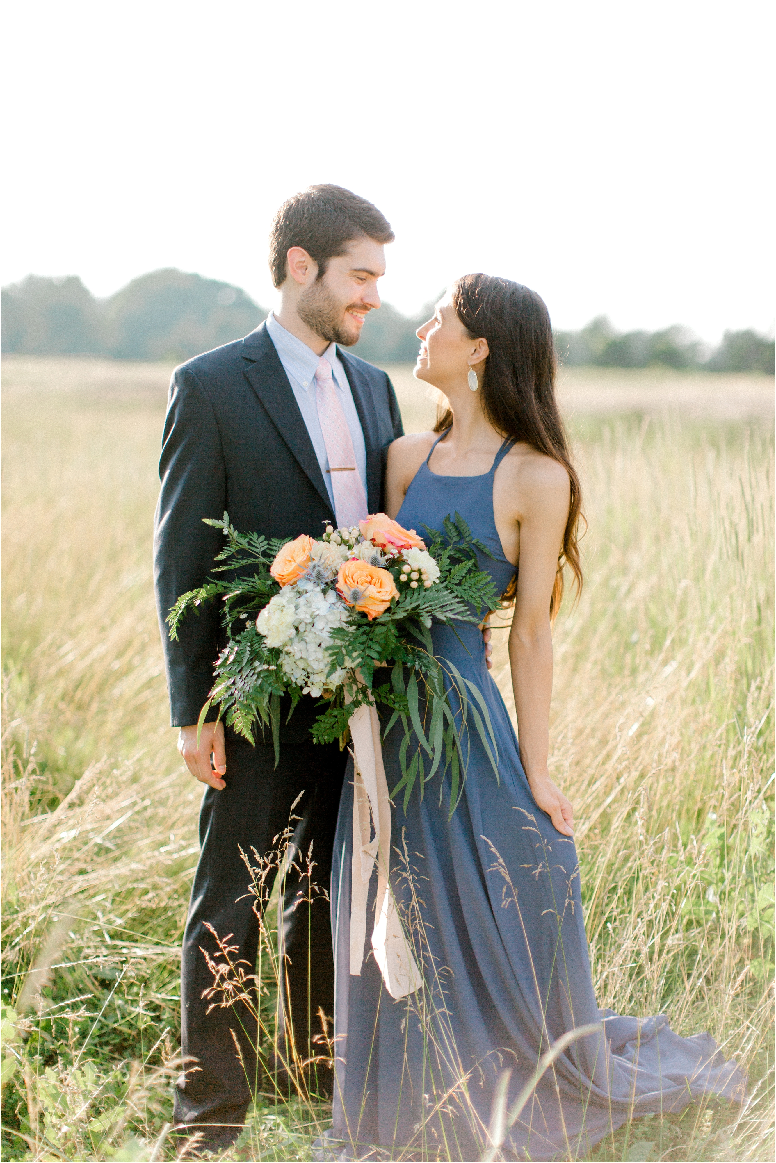 blue and peach bouquet in romantic field engagement session 