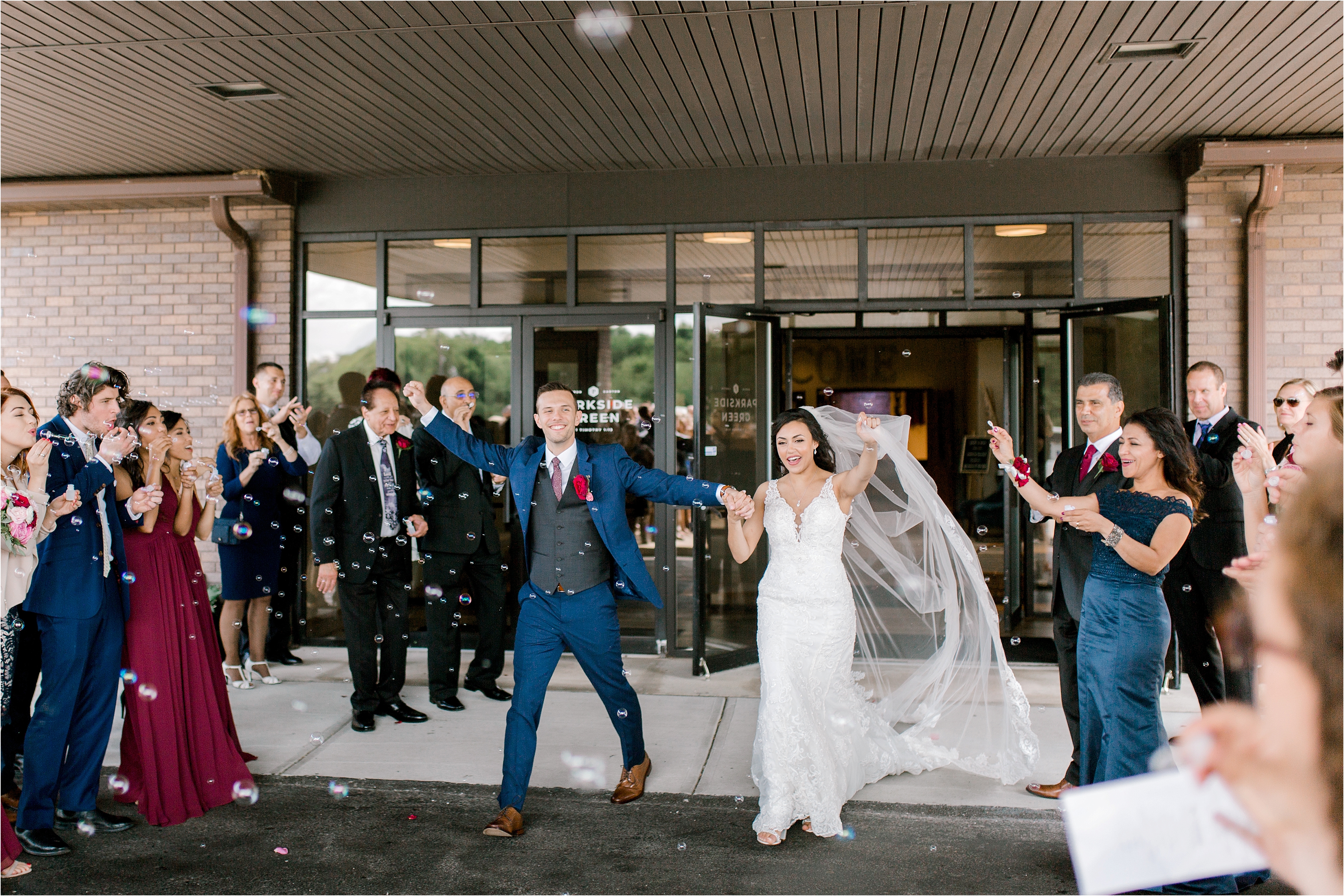 bride and groom walking through bubbles after ceremony