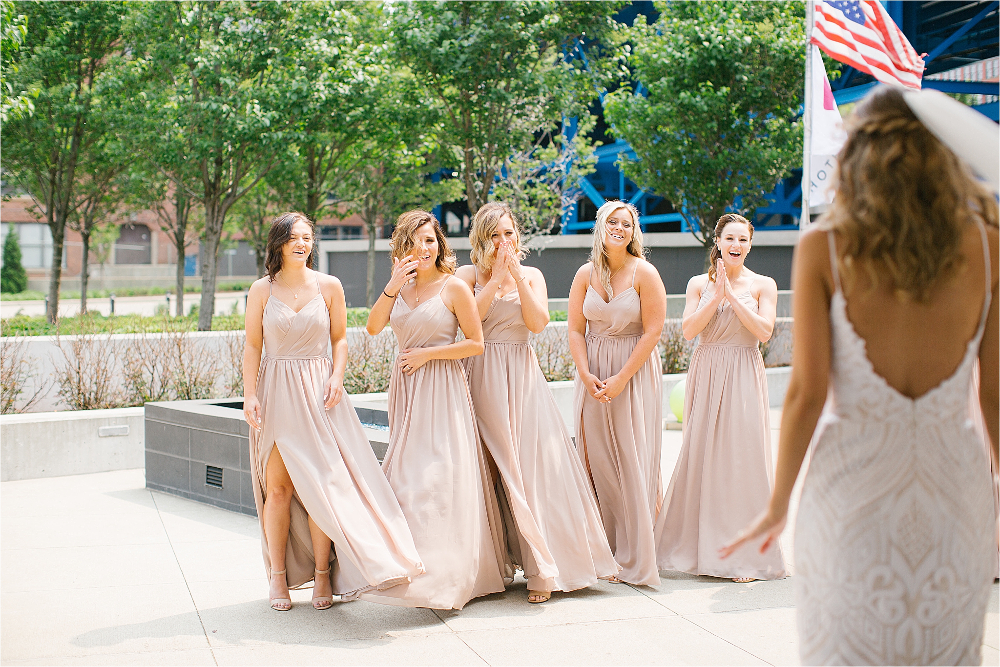 bridesmaids wearing blush dresses react to first look of bride