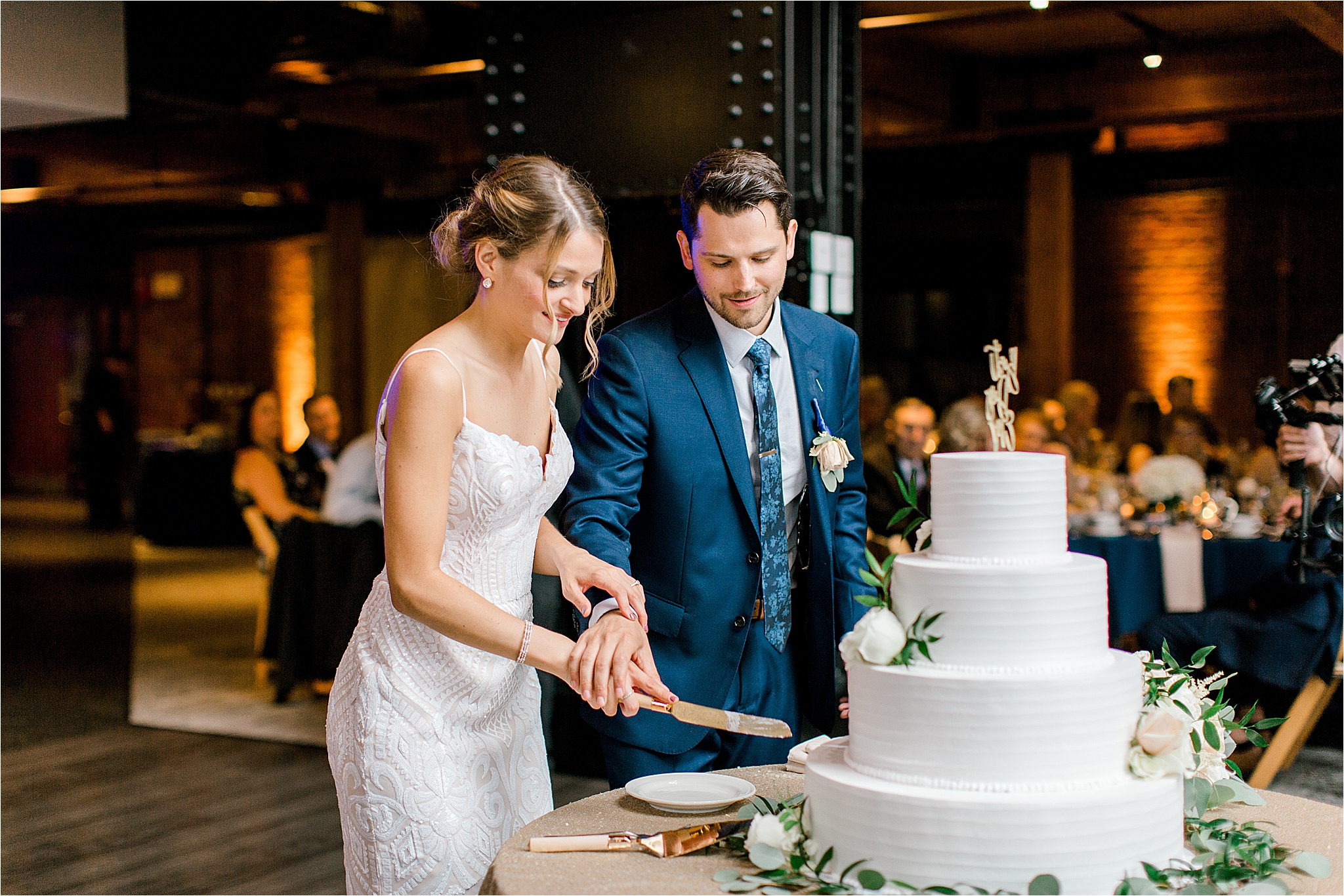 Bride and groom cutting cake by Wild Flour Bakery at Windows on the River