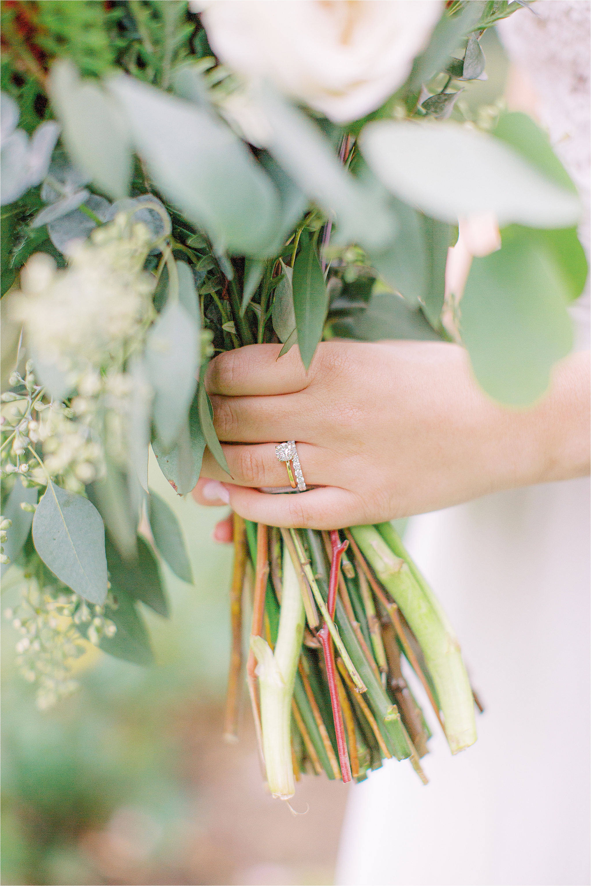 bride holding bouquet showing off gold engagement ring