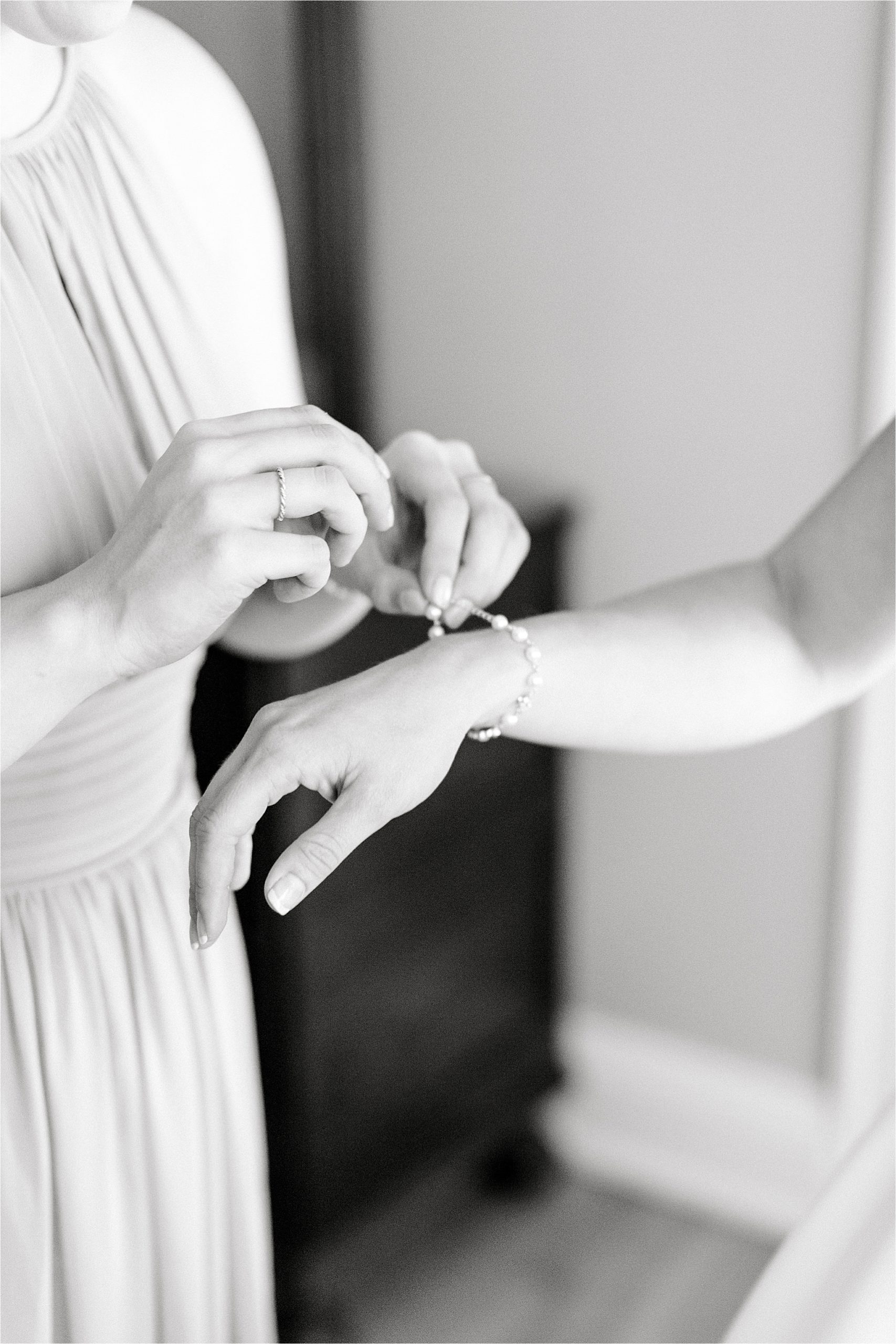 Bride puts on timeless pearl bracelet