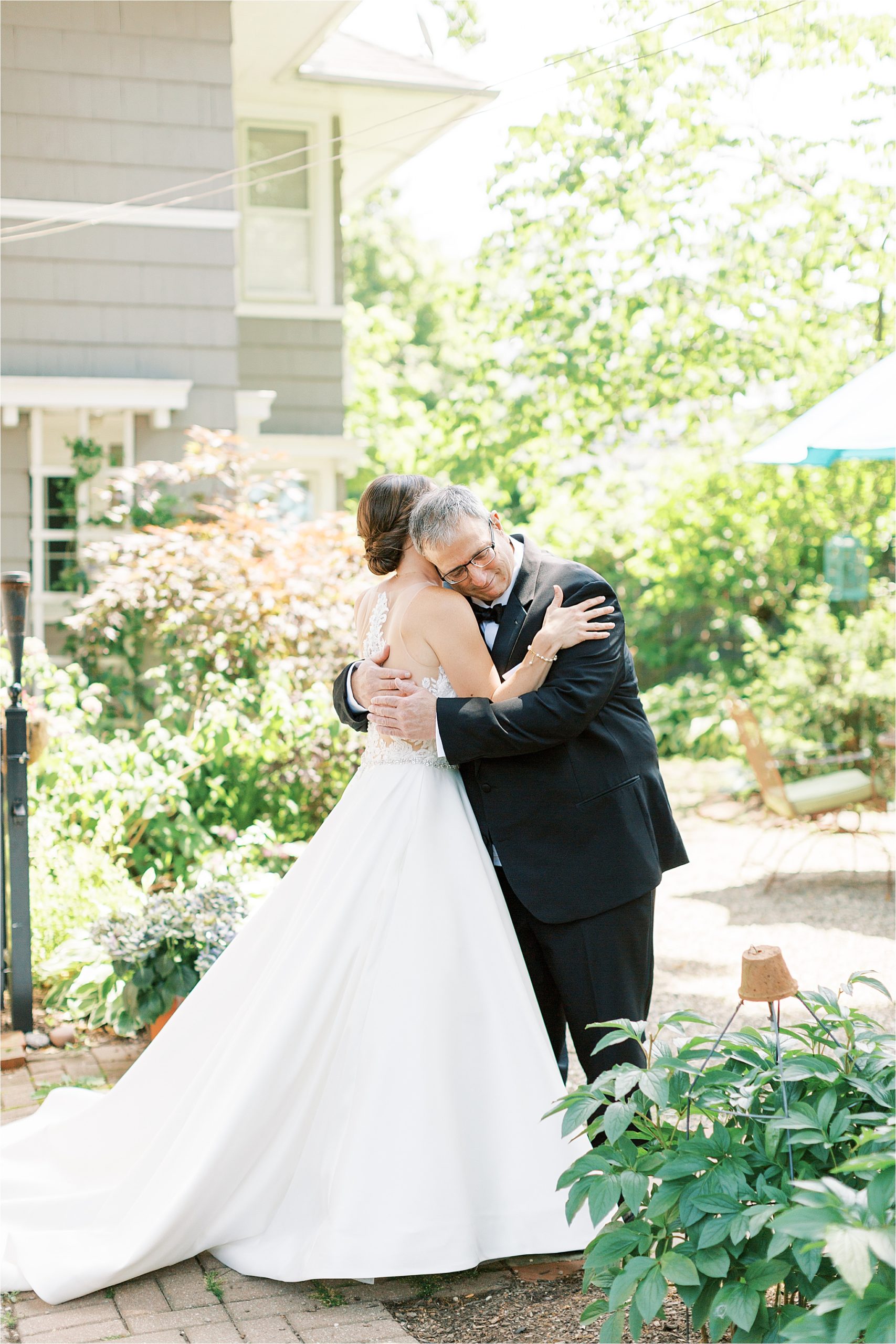 Emotional father hugs his daughter in wedding gown