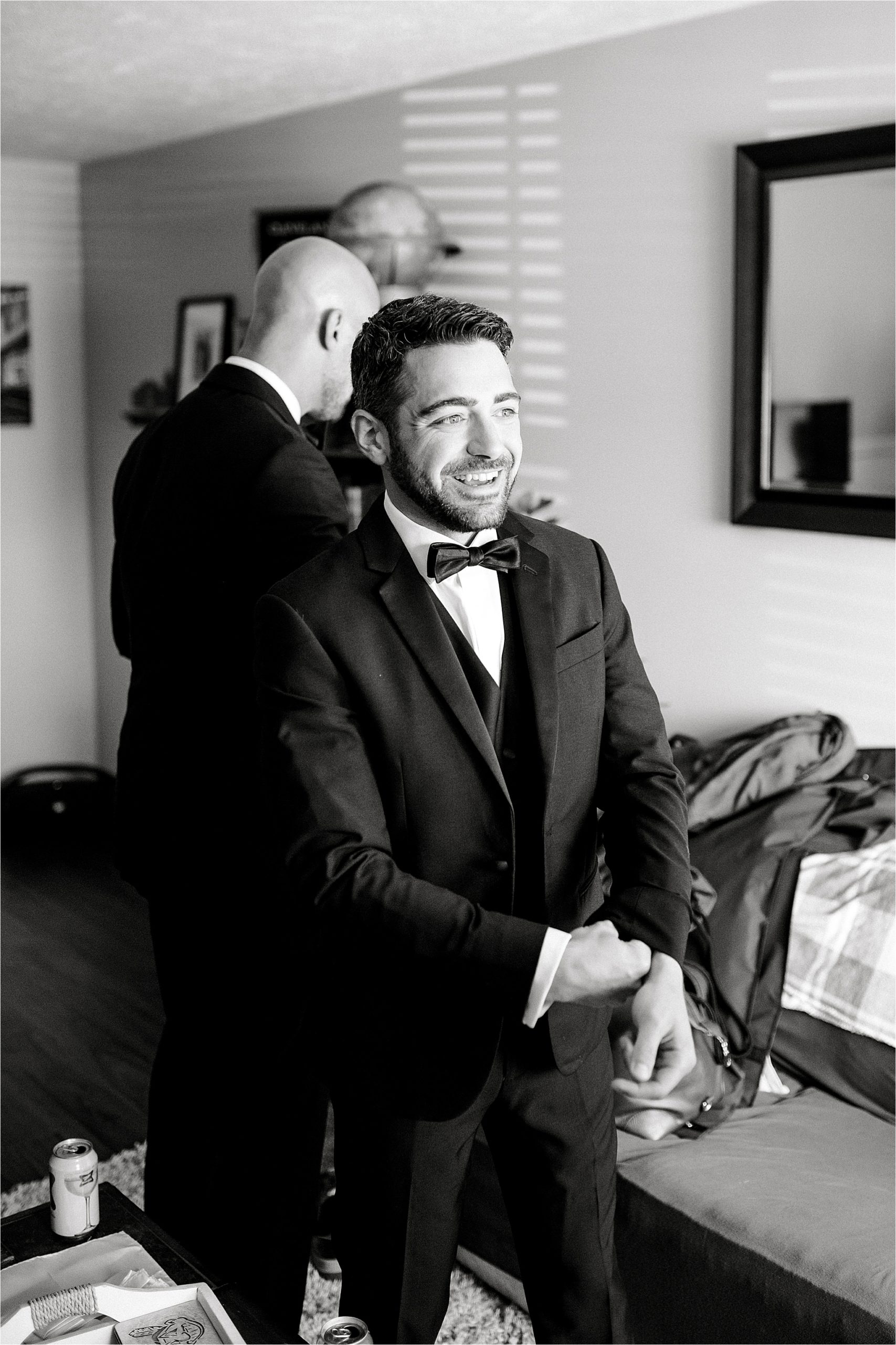 Groom putting on menswear from the Black Tux