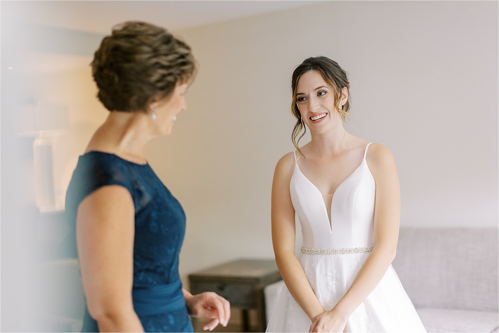 mother of the bride and bride looking at each other while getting ready