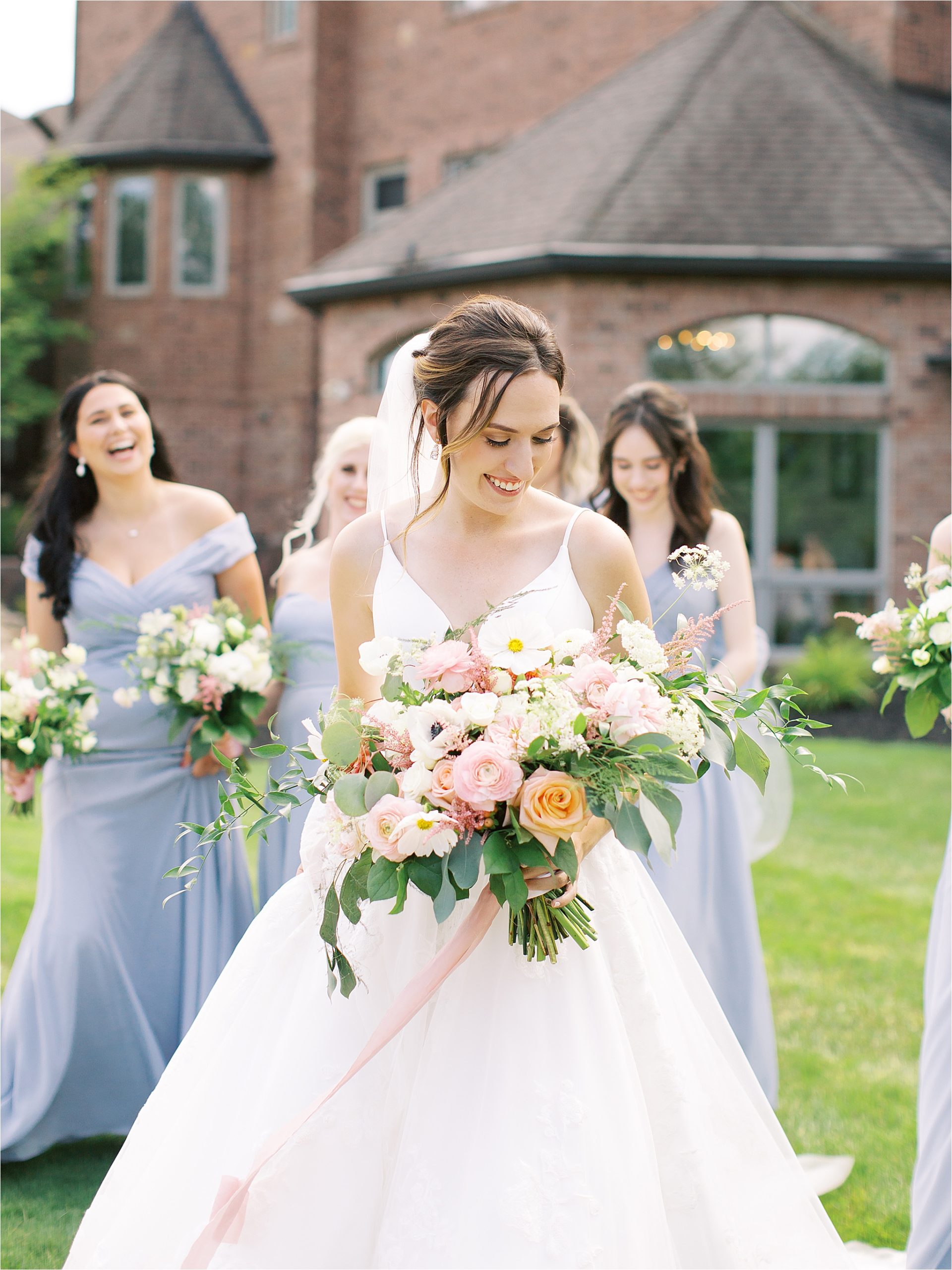 bridal candid walking with bridesmaids in front of blue heron event center
