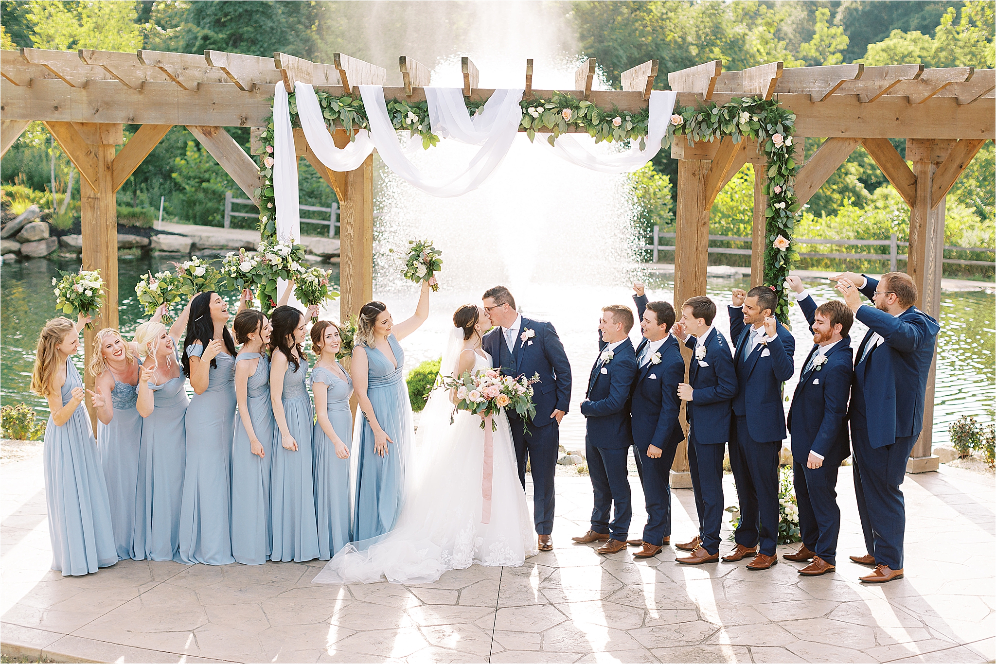 bridal party in front of fountain at blue heron wedding and event center