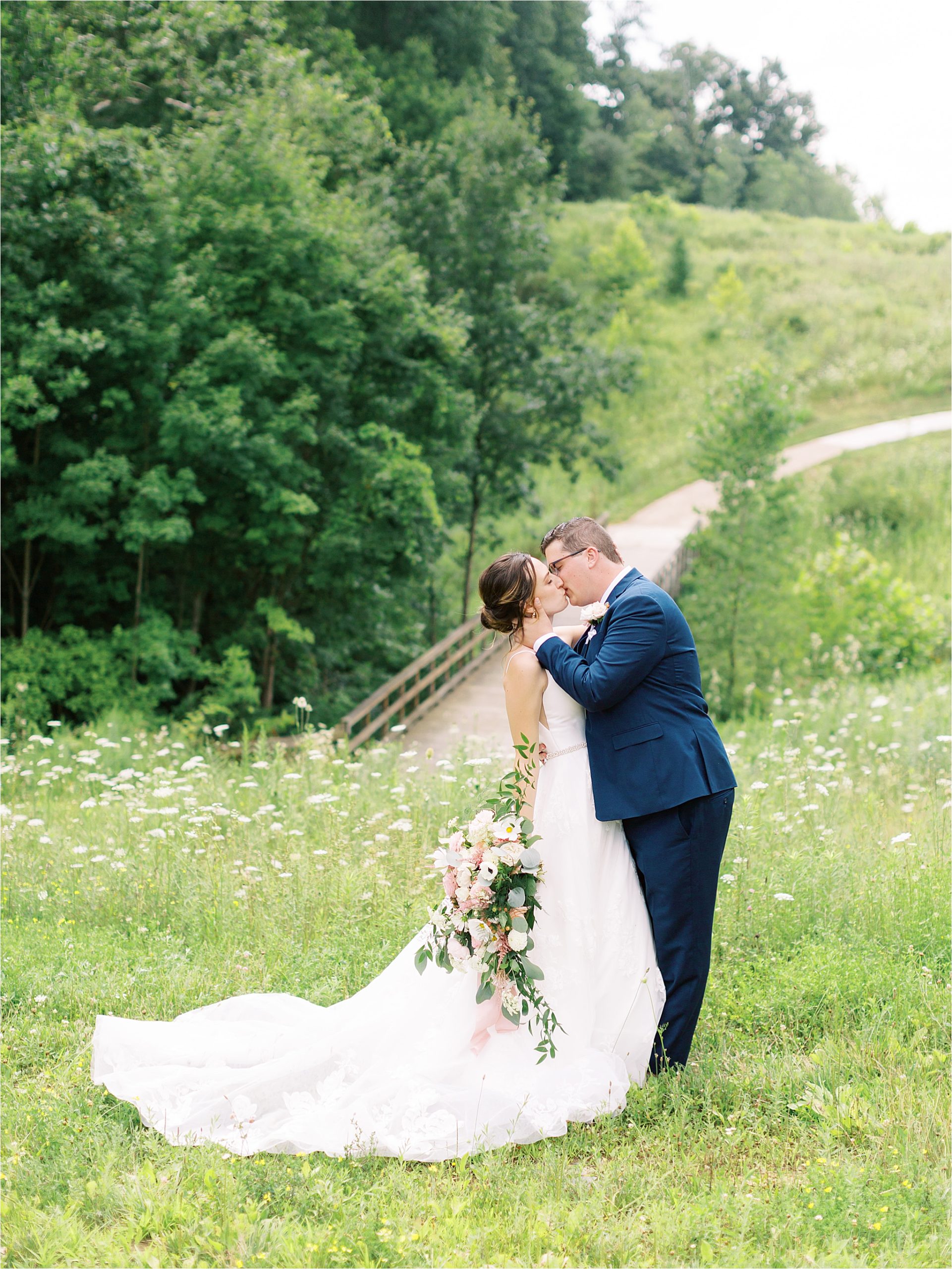 bride and groom kissing in field by Cleveland Wedding Photographers 