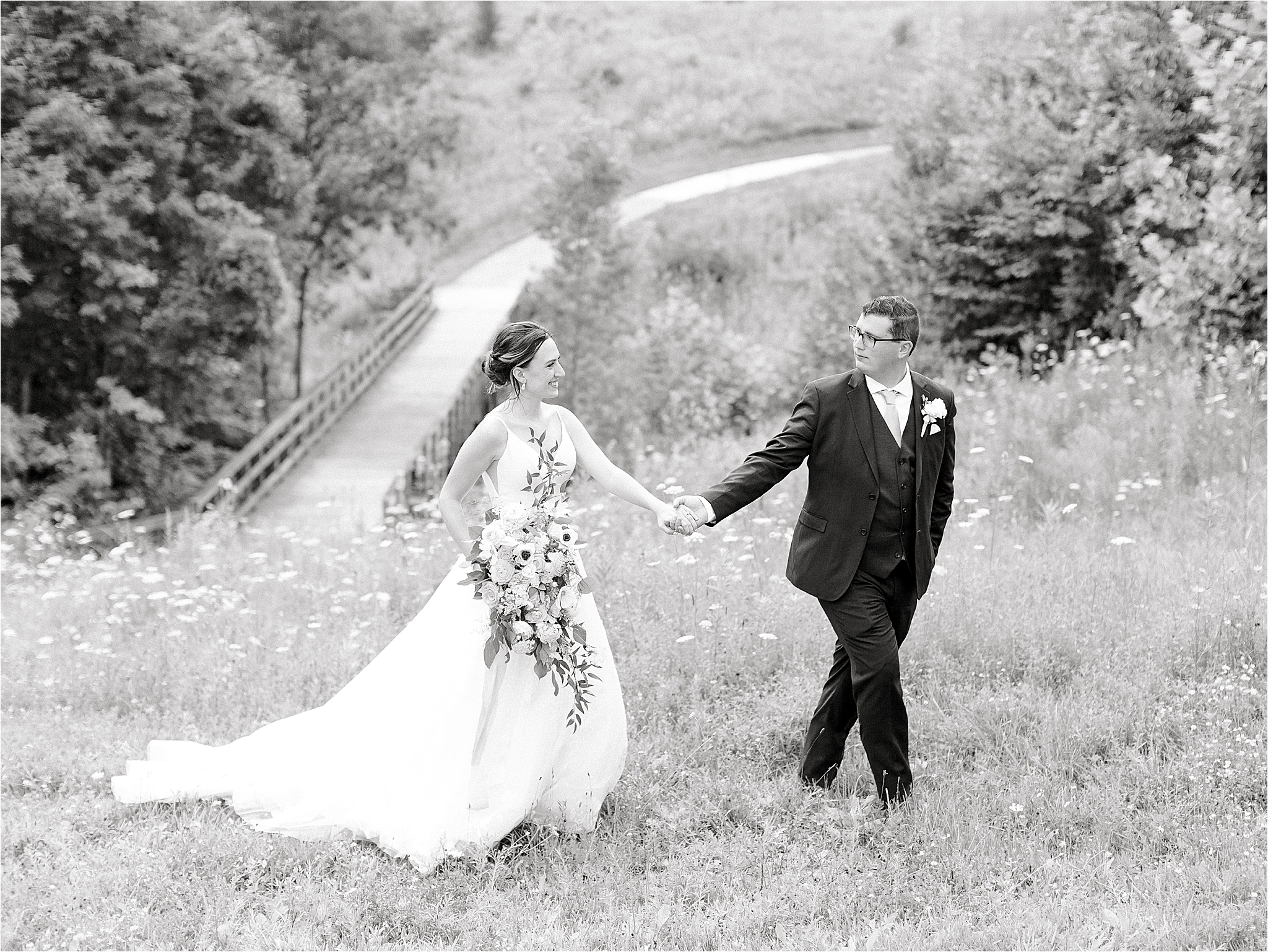 bride and groom walking through fields at medina wedding