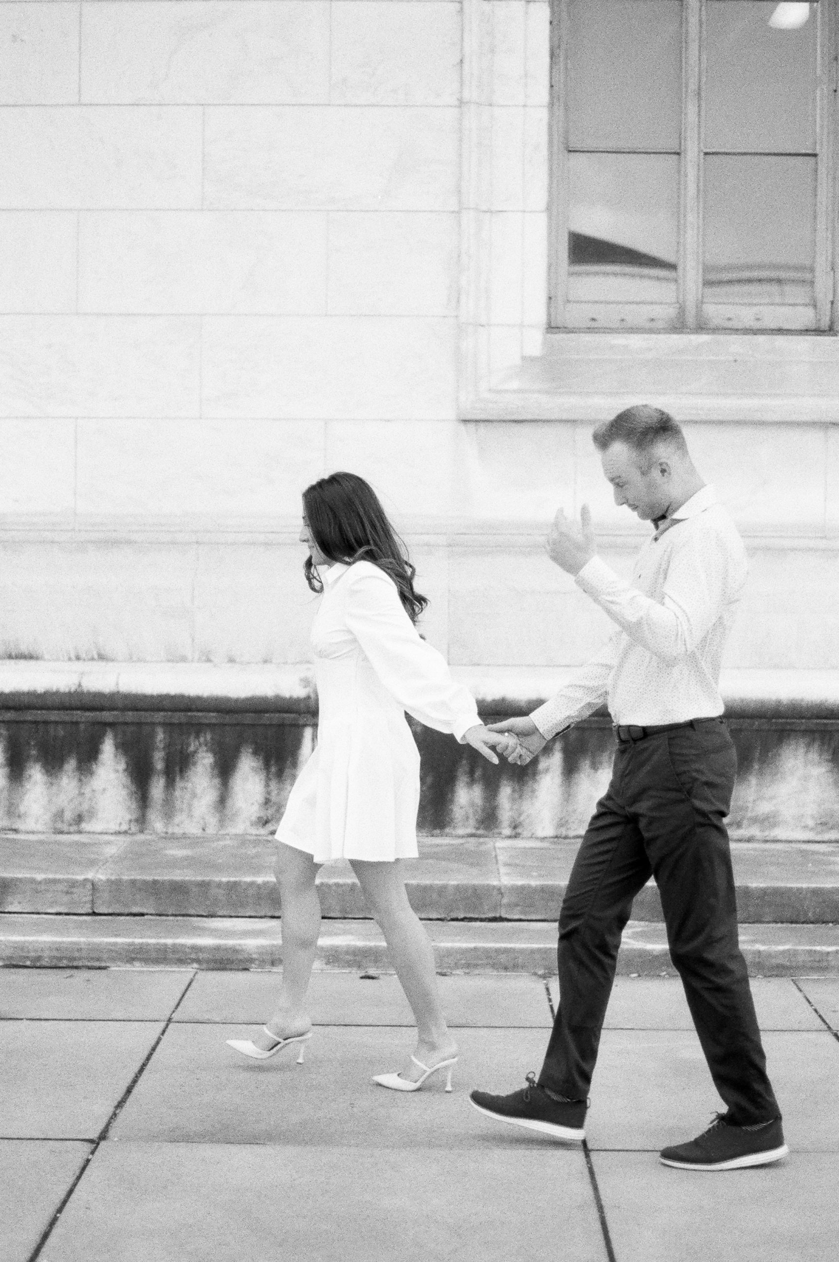 couple walking at the detroit public library during engagement session