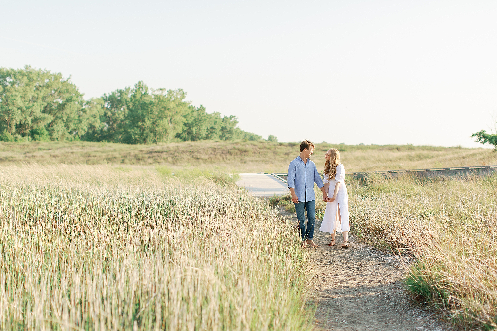 couple walking down lane at cleveland headlands beach engagement session