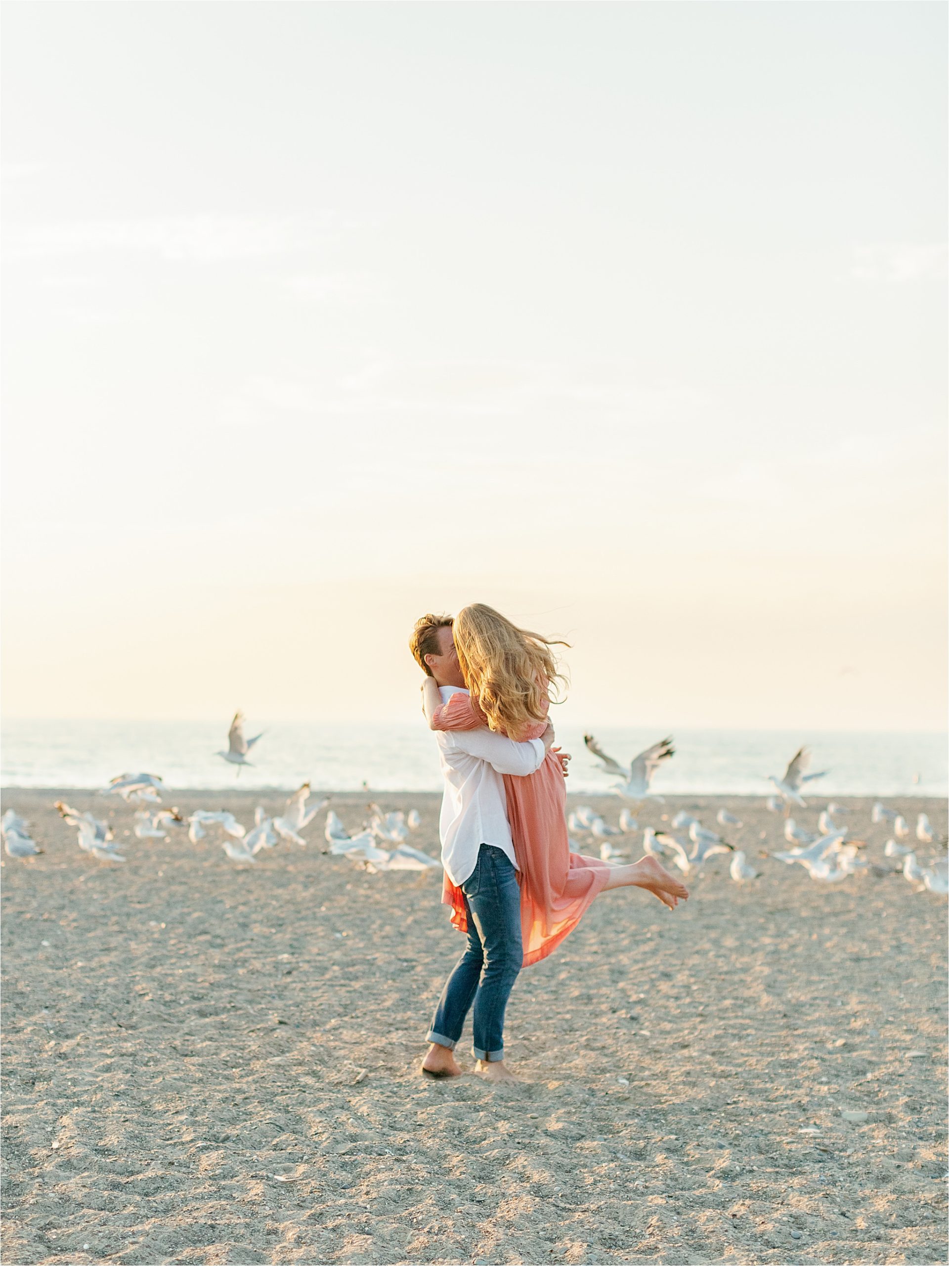 couple embracing at ocean engagement session with midwest wedding photographer