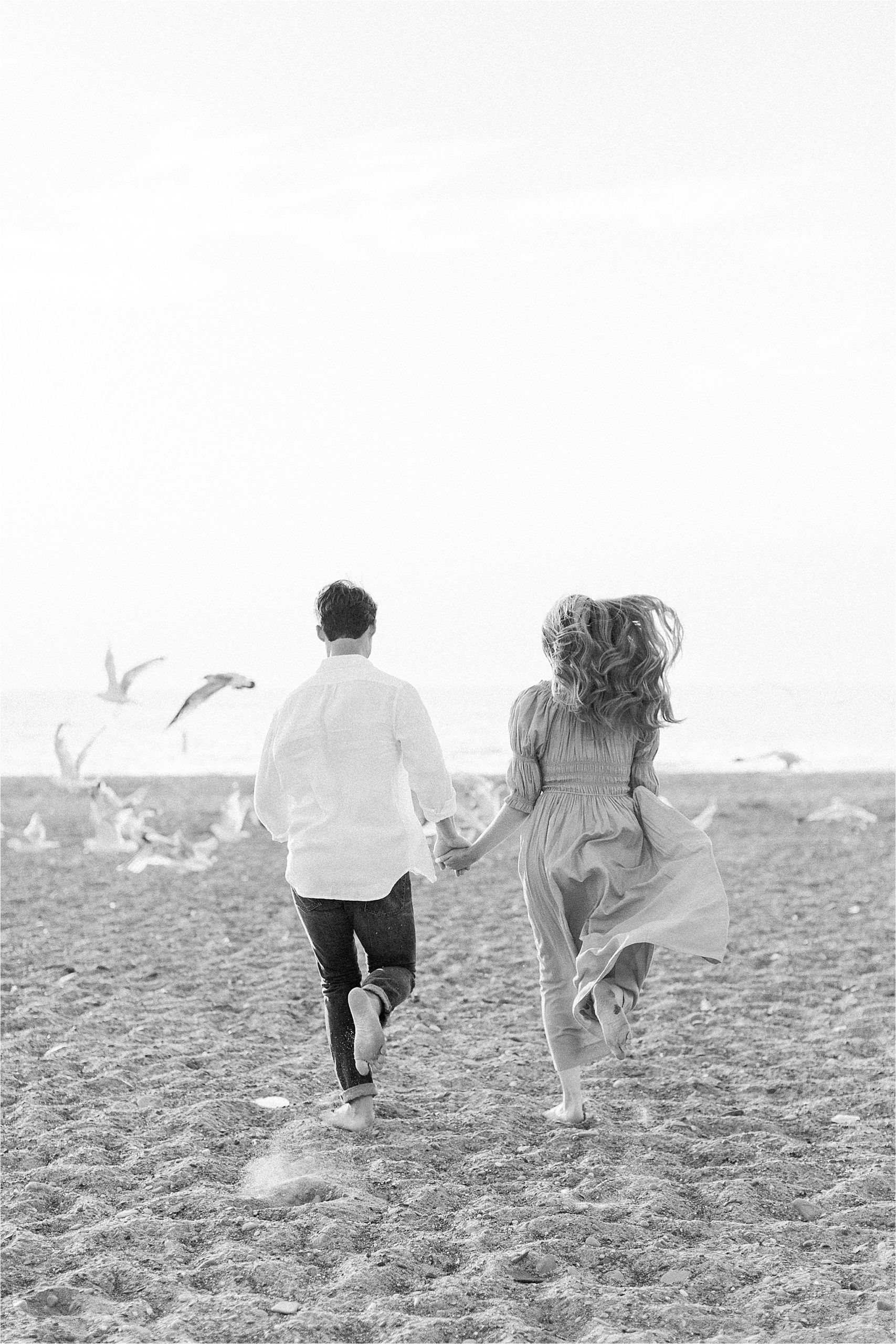couple running towards birds at east coast engagement session