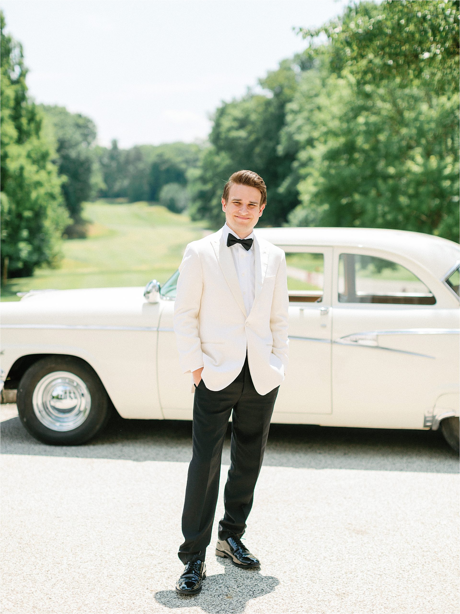 groom in front of vintage car at ohio estate wedding